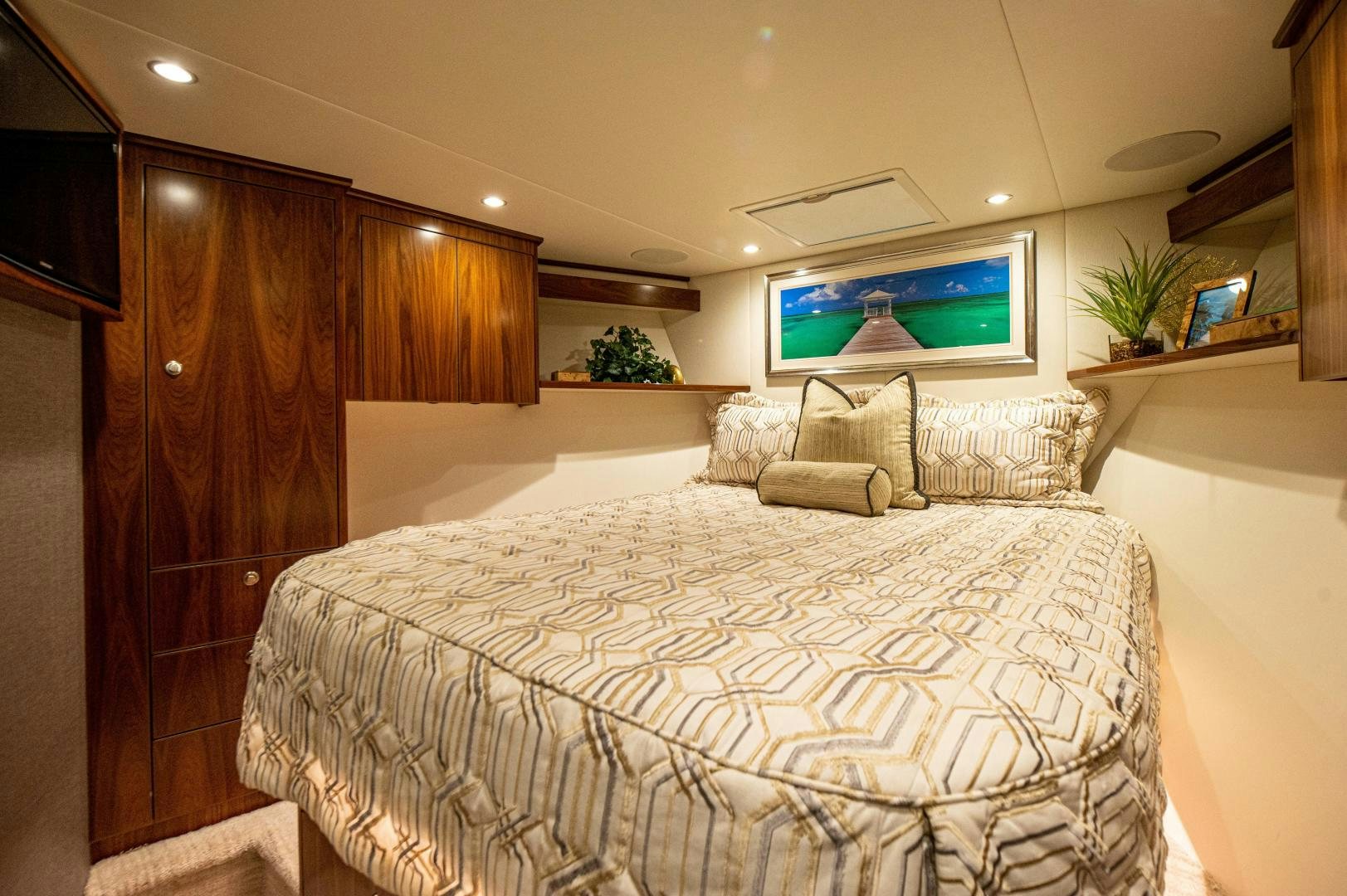 a bed with a television on the wall aboard RAGIN CAJUN Yacht for Sale