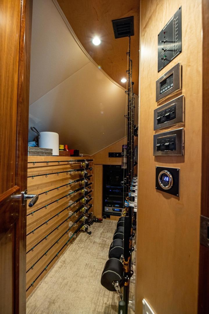 a room with a wood door and a wood cabinet with a black framed mirror on it aboard RAGIN CAJUN Yacht for Sale