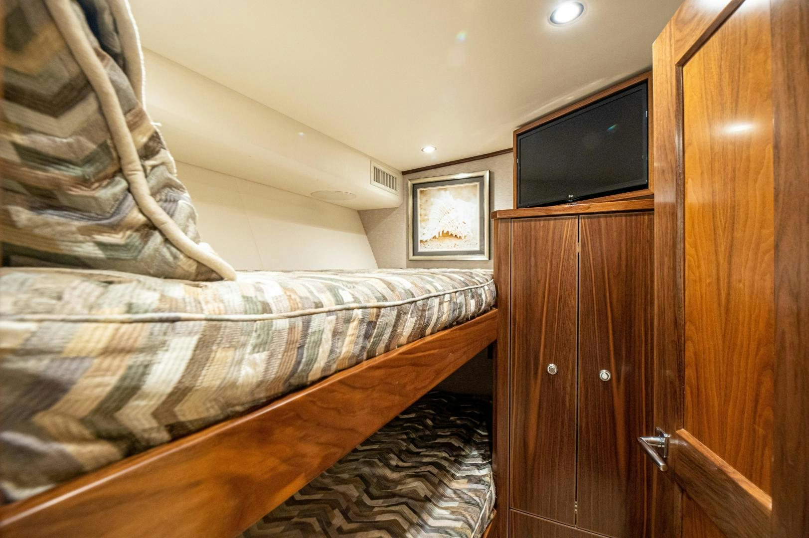a bedroom with a bed and a television aboard RAGIN CAJUN Yacht for Sale