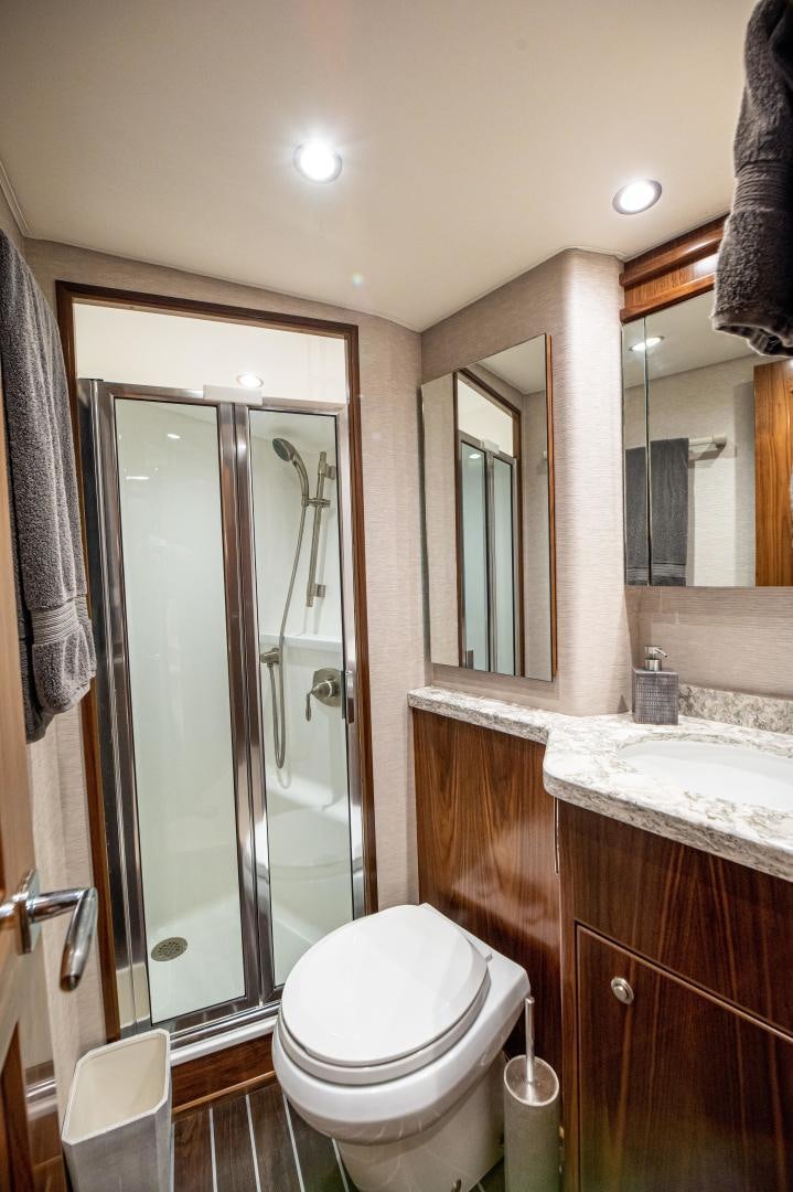 a bathroom with a glass shower door aboard RAGIN CAJUN Yacht for Sale
