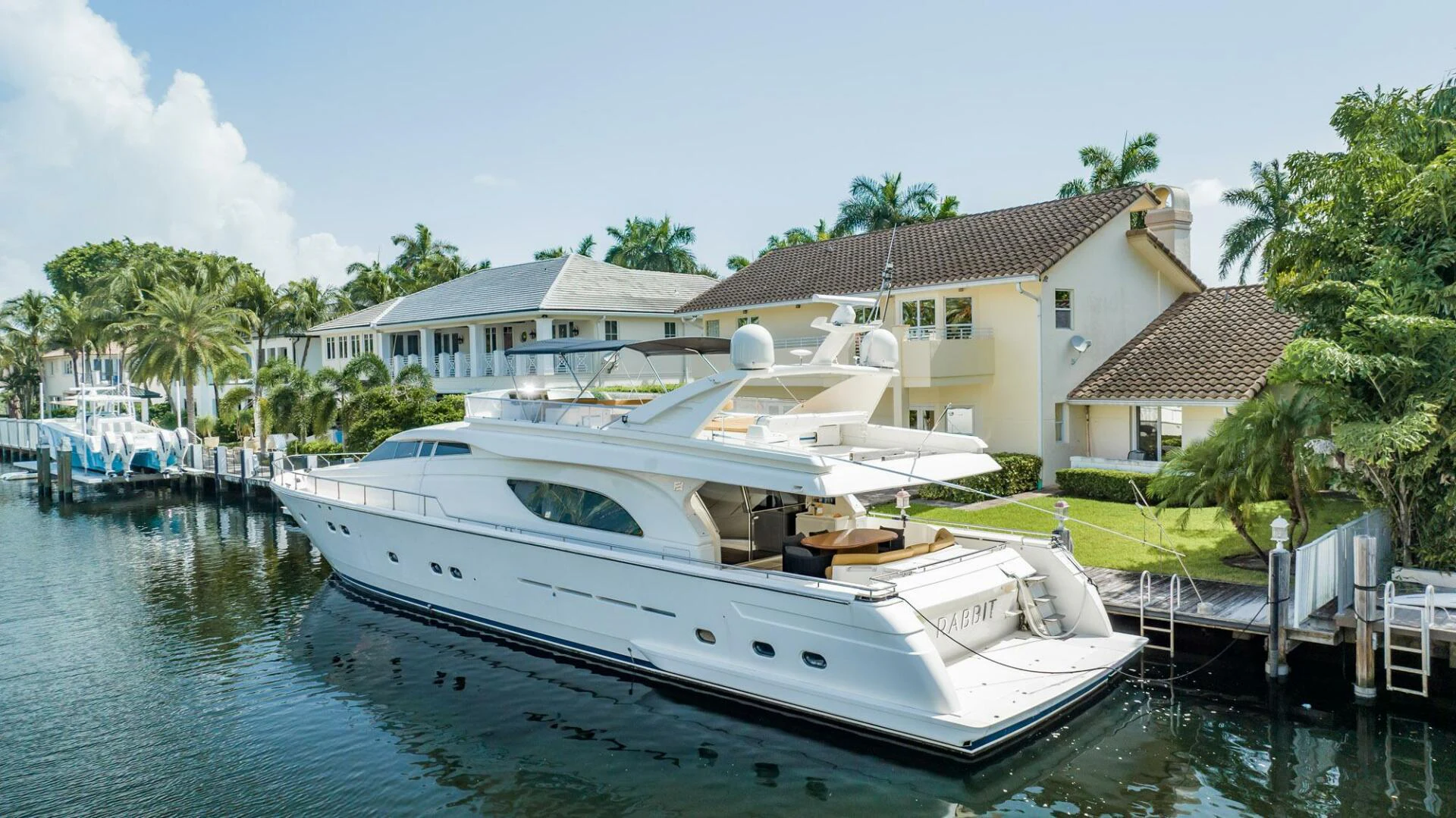 a white boat docked at a pier aboard RABBIT Yacht for Sale