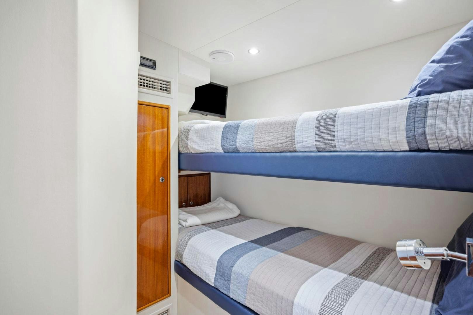 a bed with a blue and white striped blanket aboard FLYNN'S FOLLY III Yacht for Sale