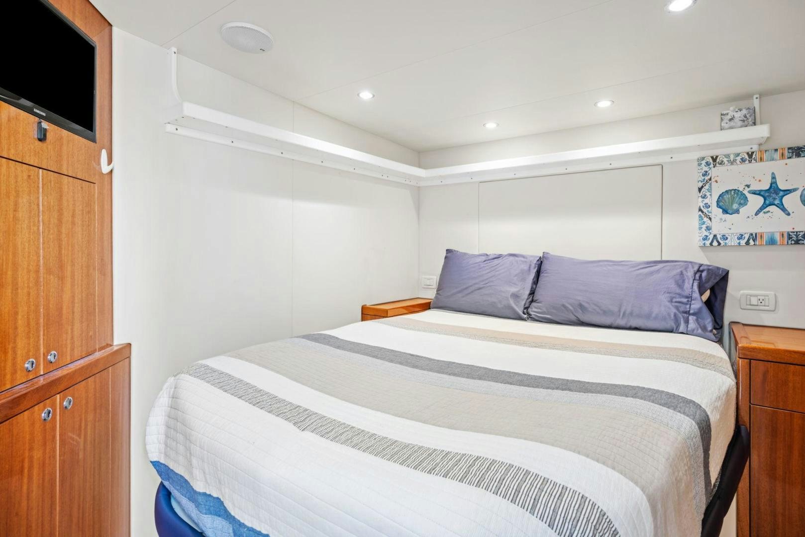 a bedroom with a bed and a television aboard FLYNN'S FOLLY III Yacht for Sale