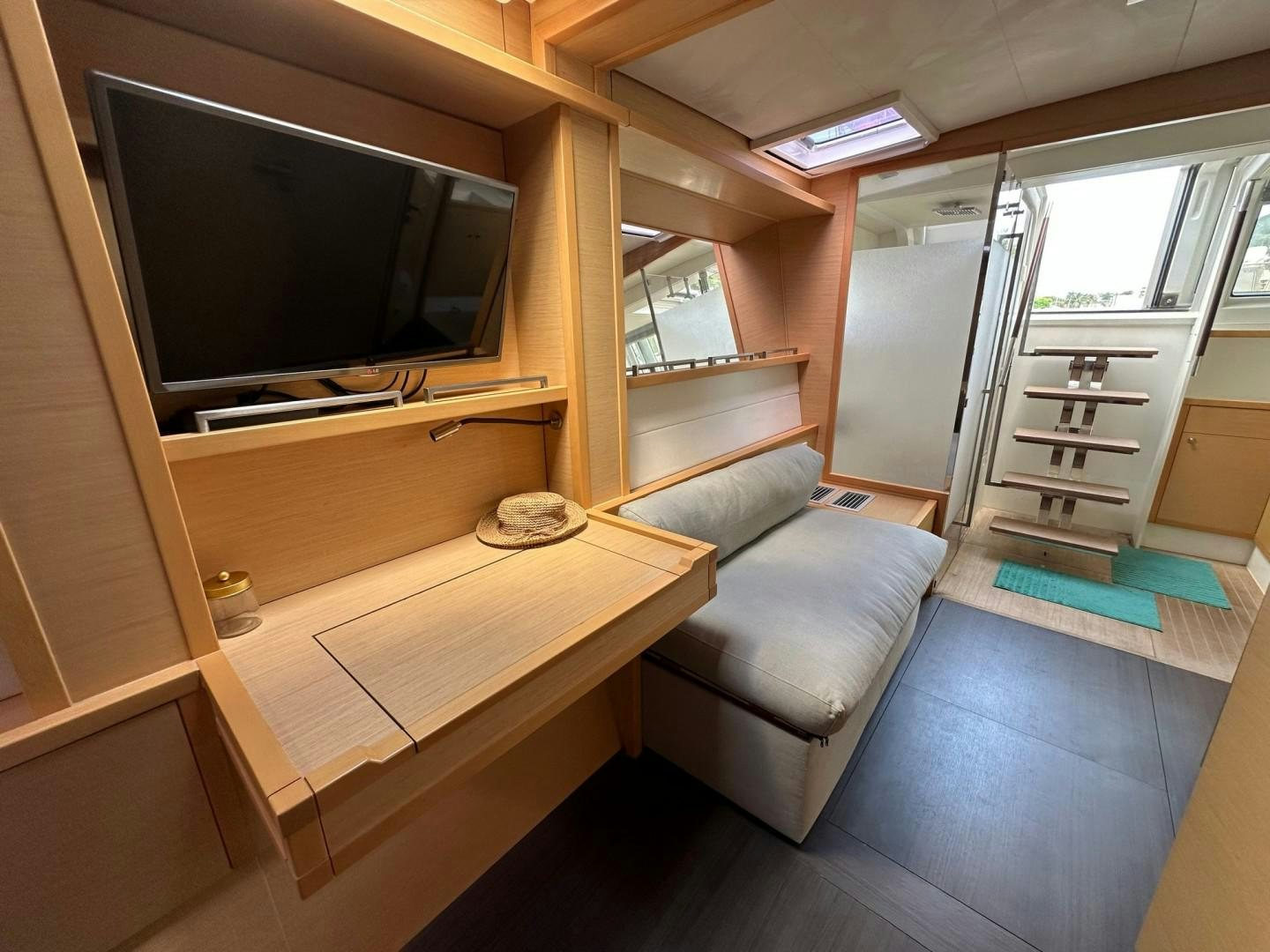 a living room with a tv and a table aboard OCEAN VIEW Yacht for Sale
