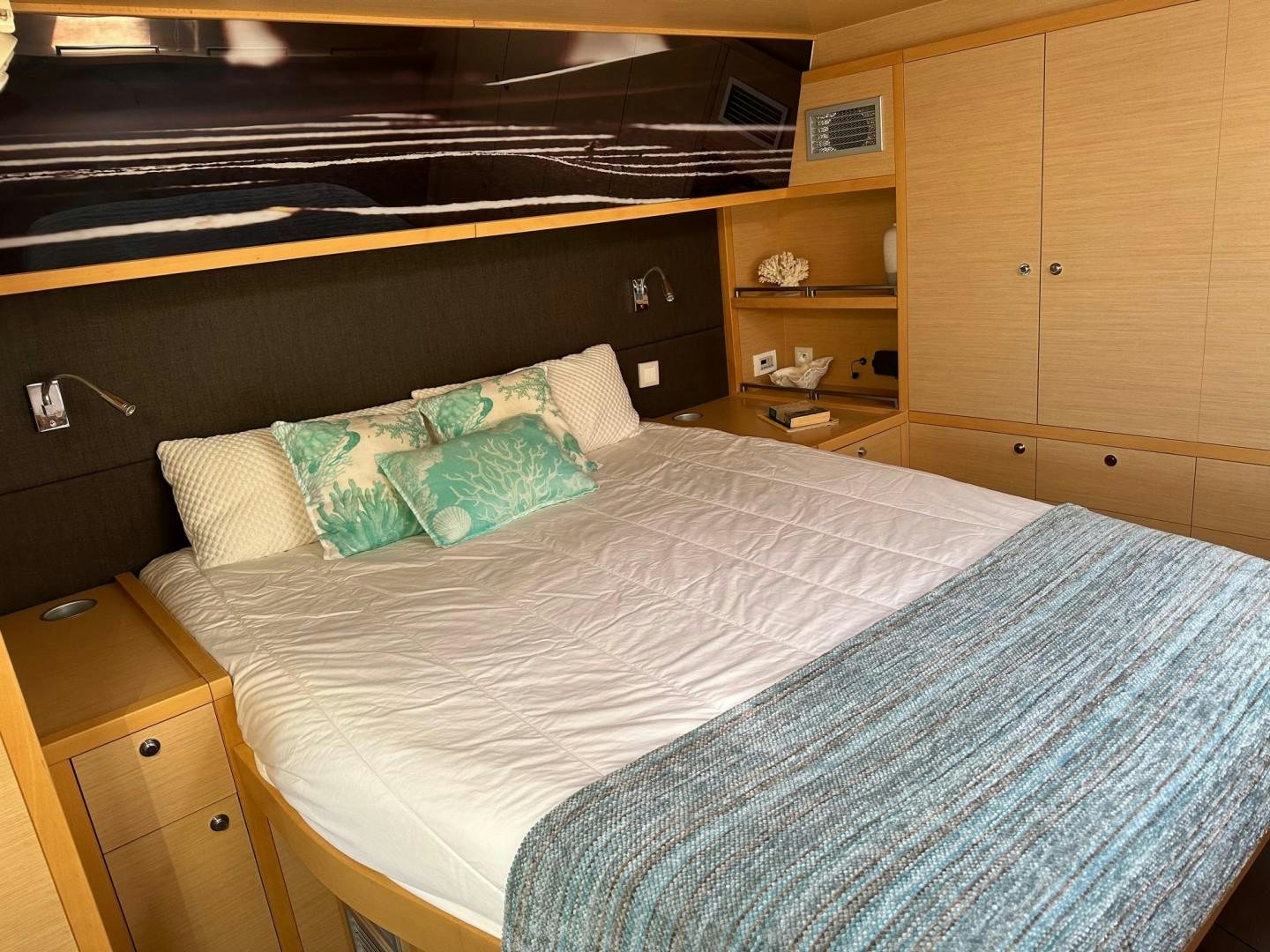 a bed with a blue and white comforter and pillows aboard OCEAN VIEW Yacht for Sale