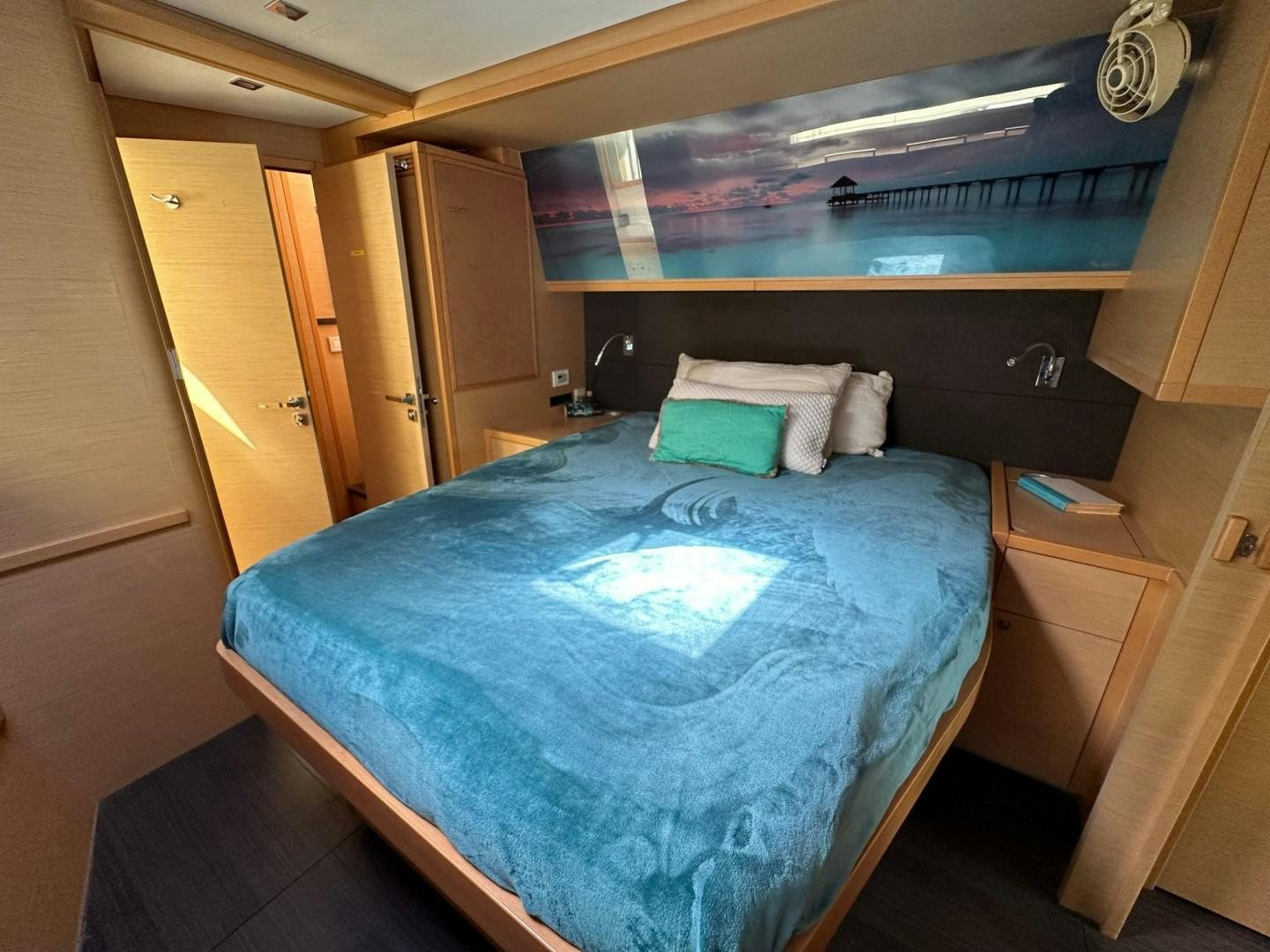 a bed with a blue comforter aboard OCEAN VIEW Yacht for Sale