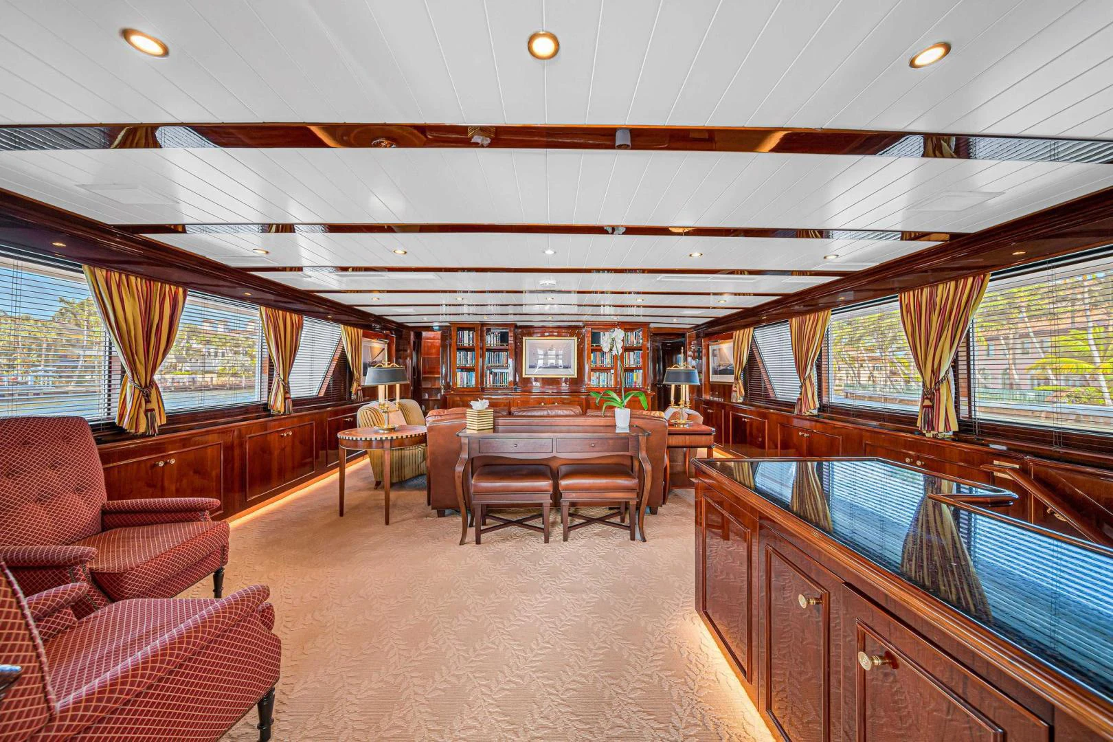 a large living room with a wood table and chairs aboard INEVITABLE Yacht for Sale