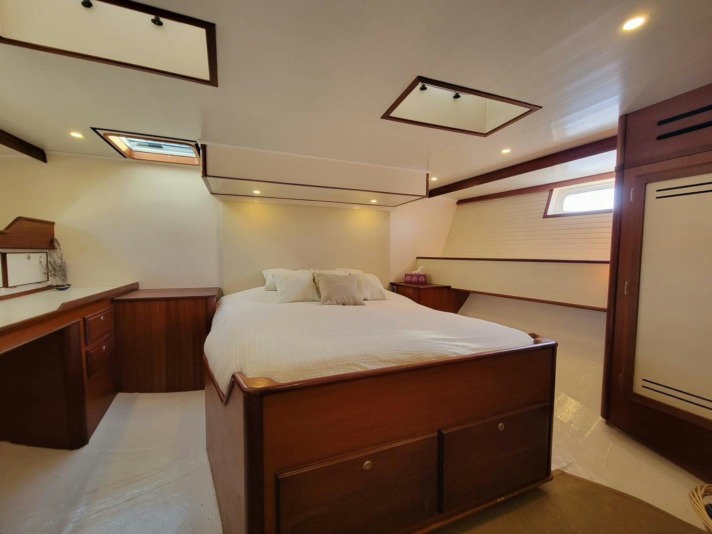 a bedroom with a bed and a desk aboard TARA Yacht for Sale