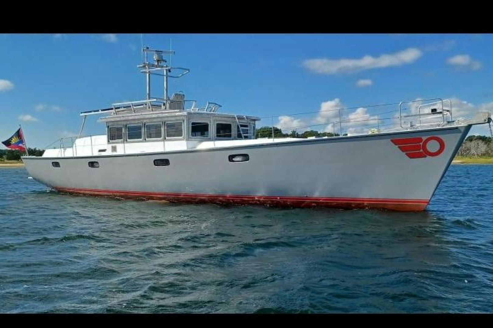 a red and white boat in the water aboard TARA Yacht for Sale