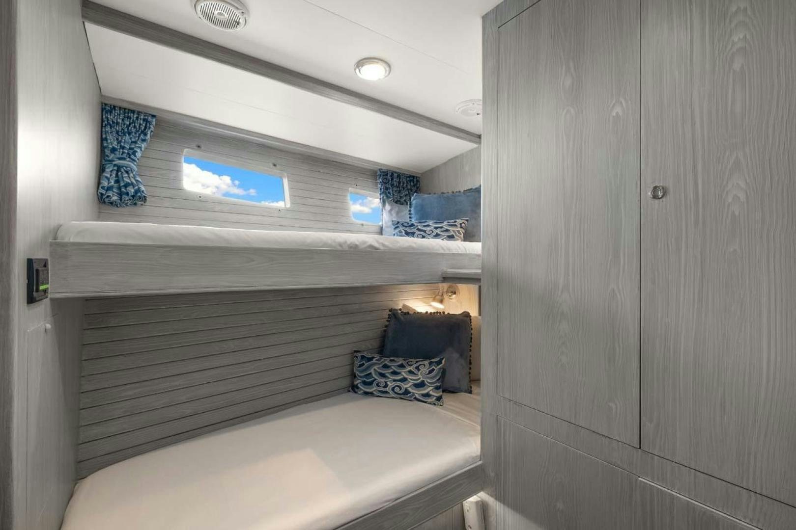 a bed with a white bed and a white wall aboard PIVOT Yacht for Sale