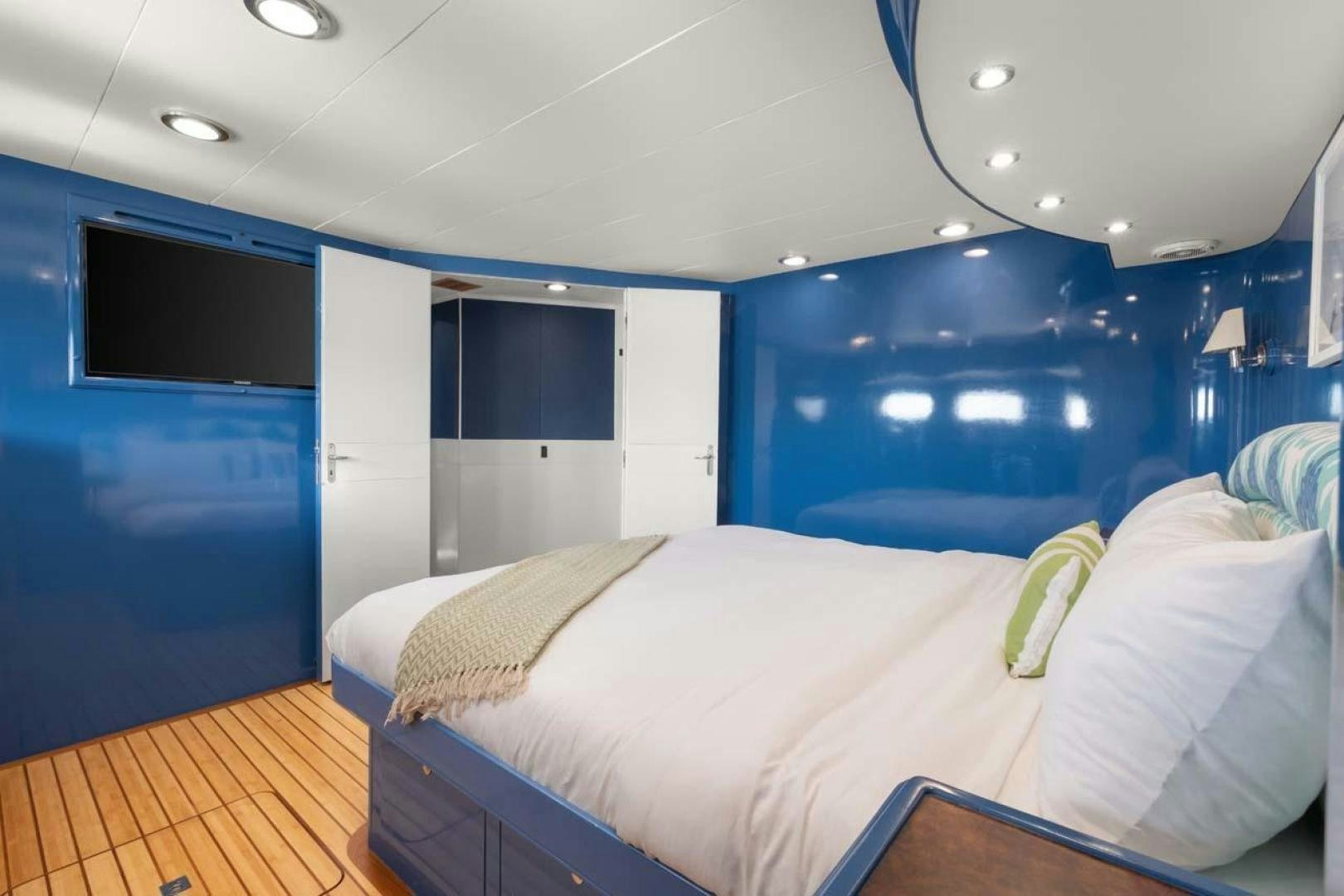 a room with a bed and a television aboard PIVOT Yacht for Sale