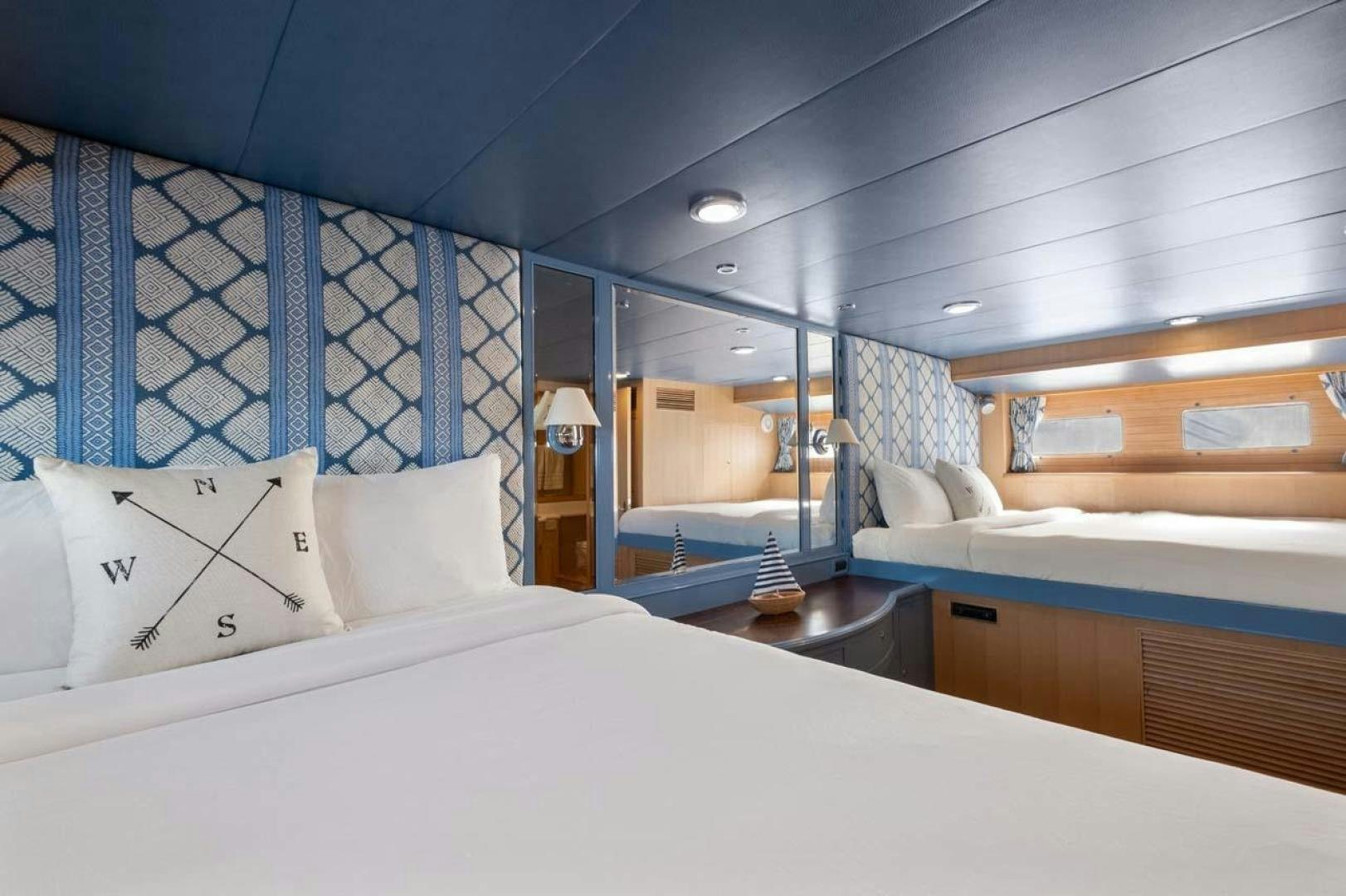 a room with a bed and a mirror aboard PIVOT Yacht for Sale