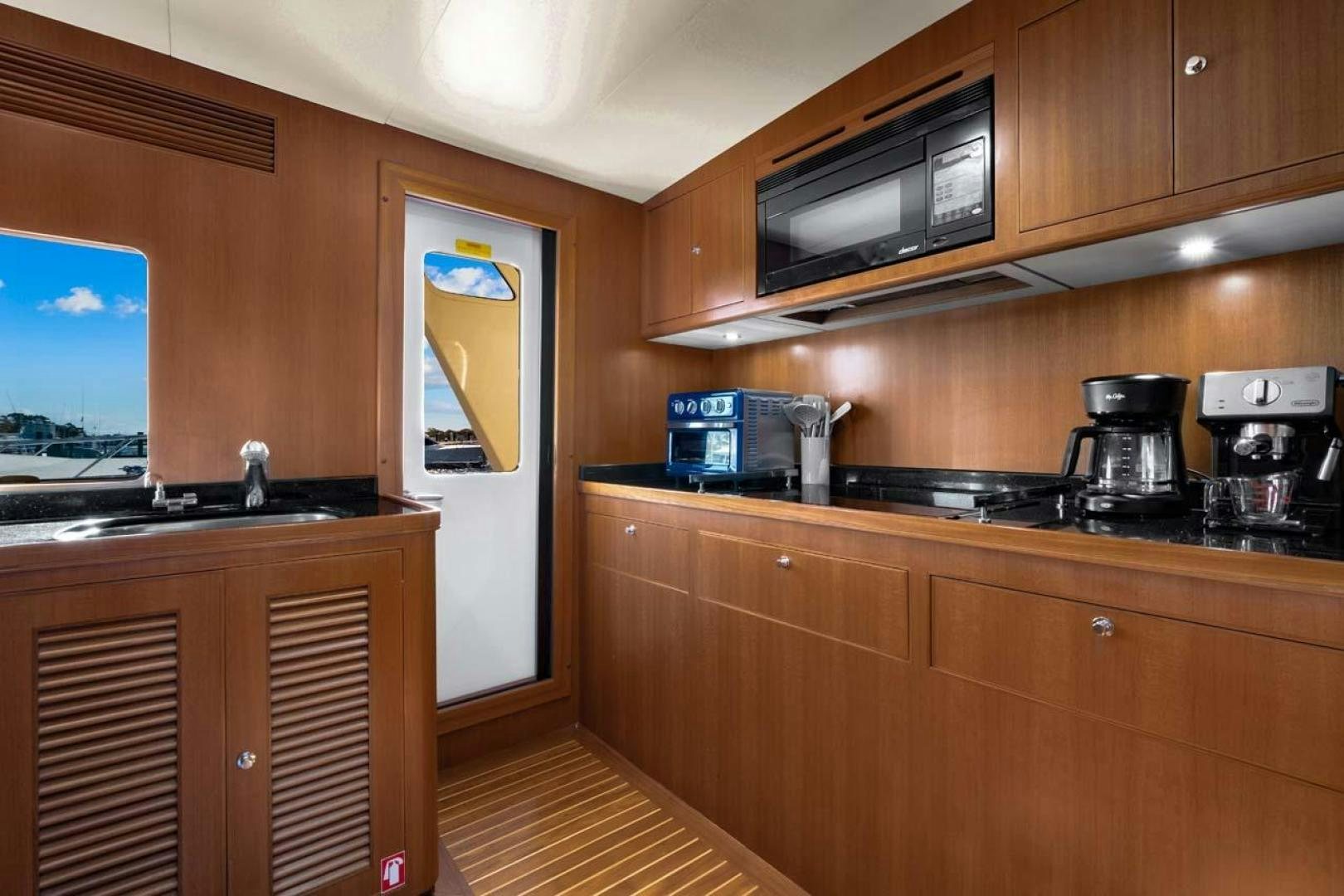 a kitchen with wooden cabinets aboard PIVOT Yacht for Sale
