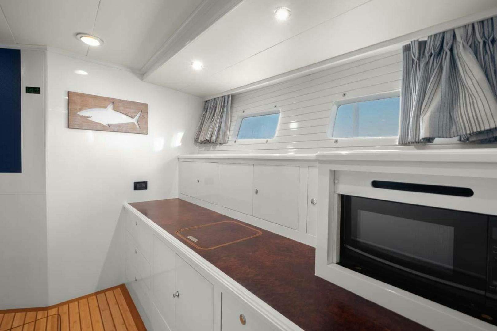 a kitchen with white cabinets aboard PIVOT Yacht for Sale