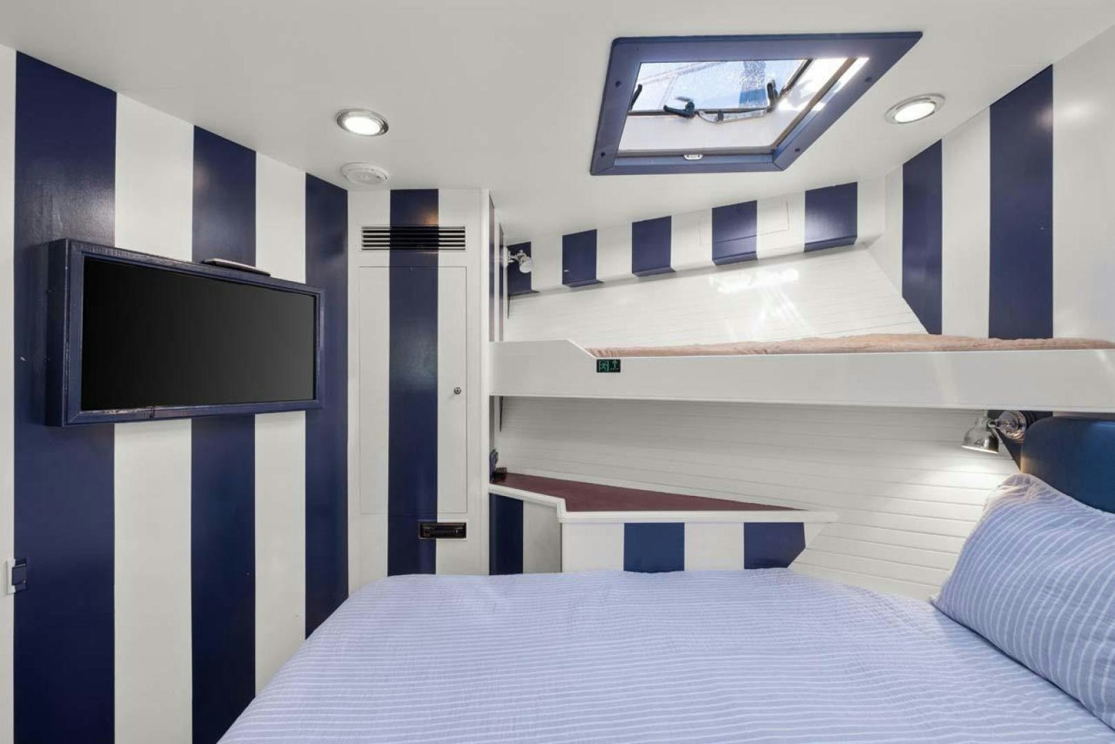 a room with a bed and a tv aboard PIVOT Yacht for Sale