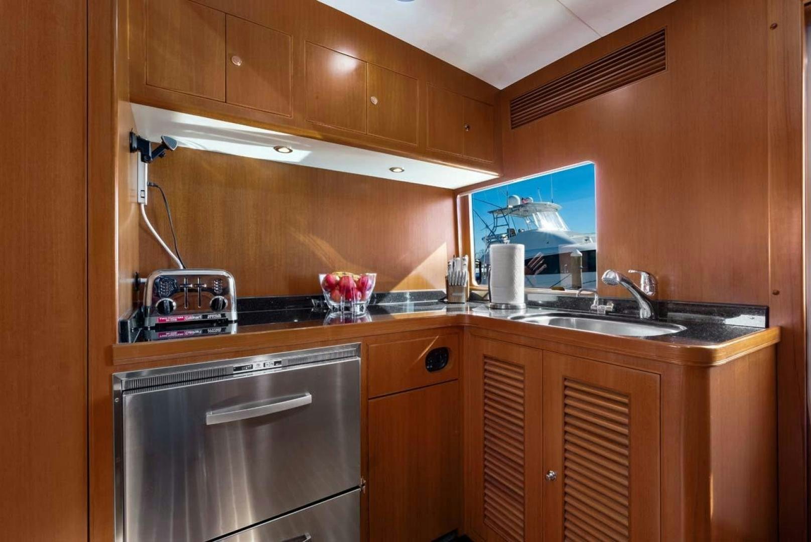 a kitchen with wooden cabinets aboard PIVOT Yacht for Sale