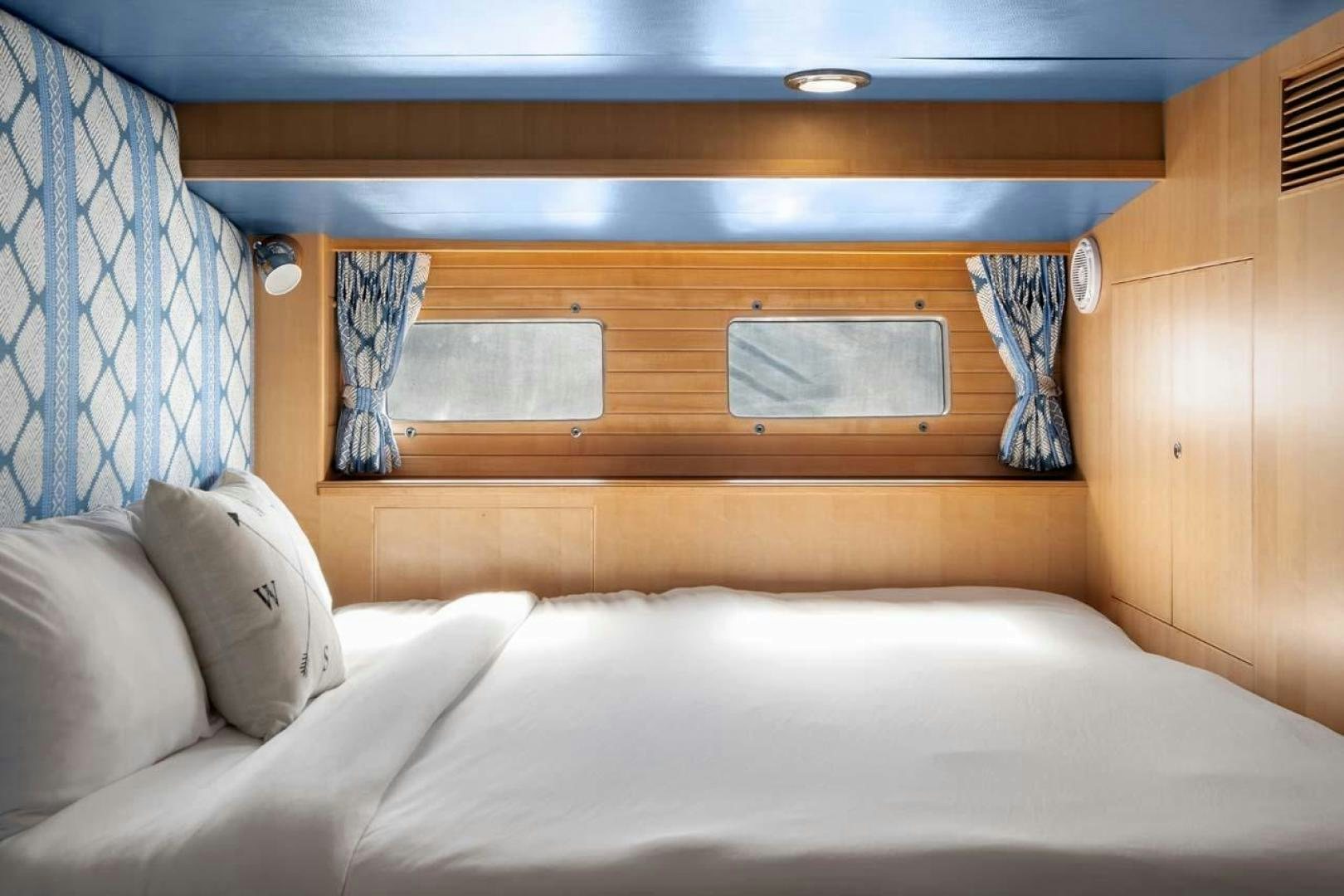 a bed with a white sheet and pillows aboard PIVOT Yacht for Sale