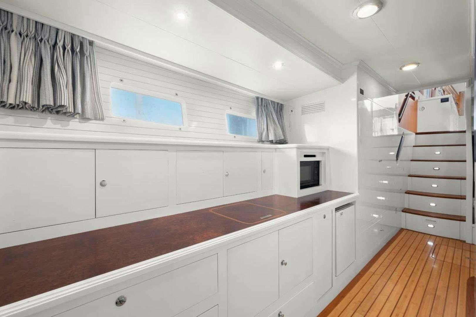 a kitchen with white cabinets aboard PIVOT Yacht for Sale