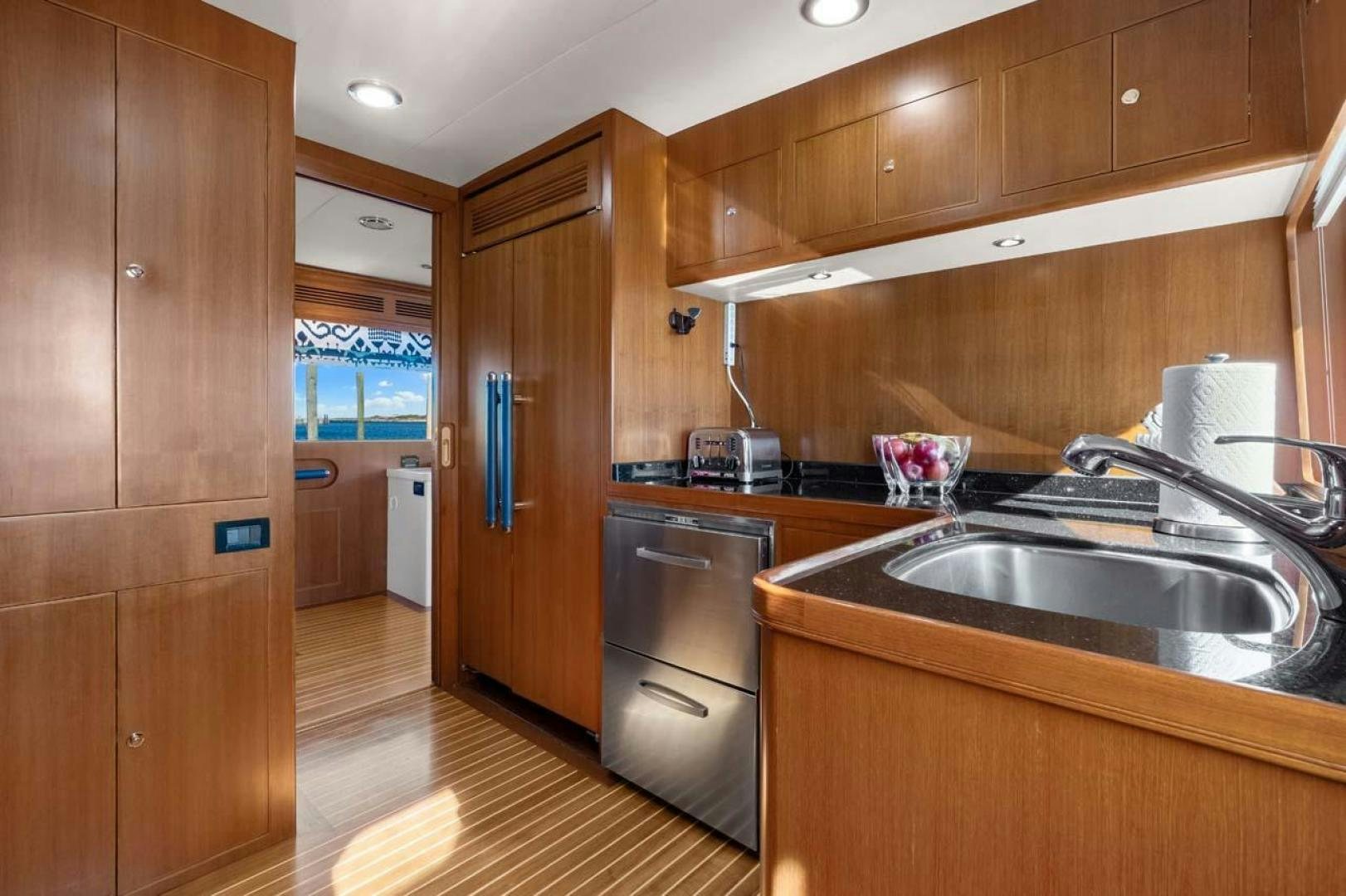 a kitchen with wooden cabinets aboard PIVOT Yacht for Sale