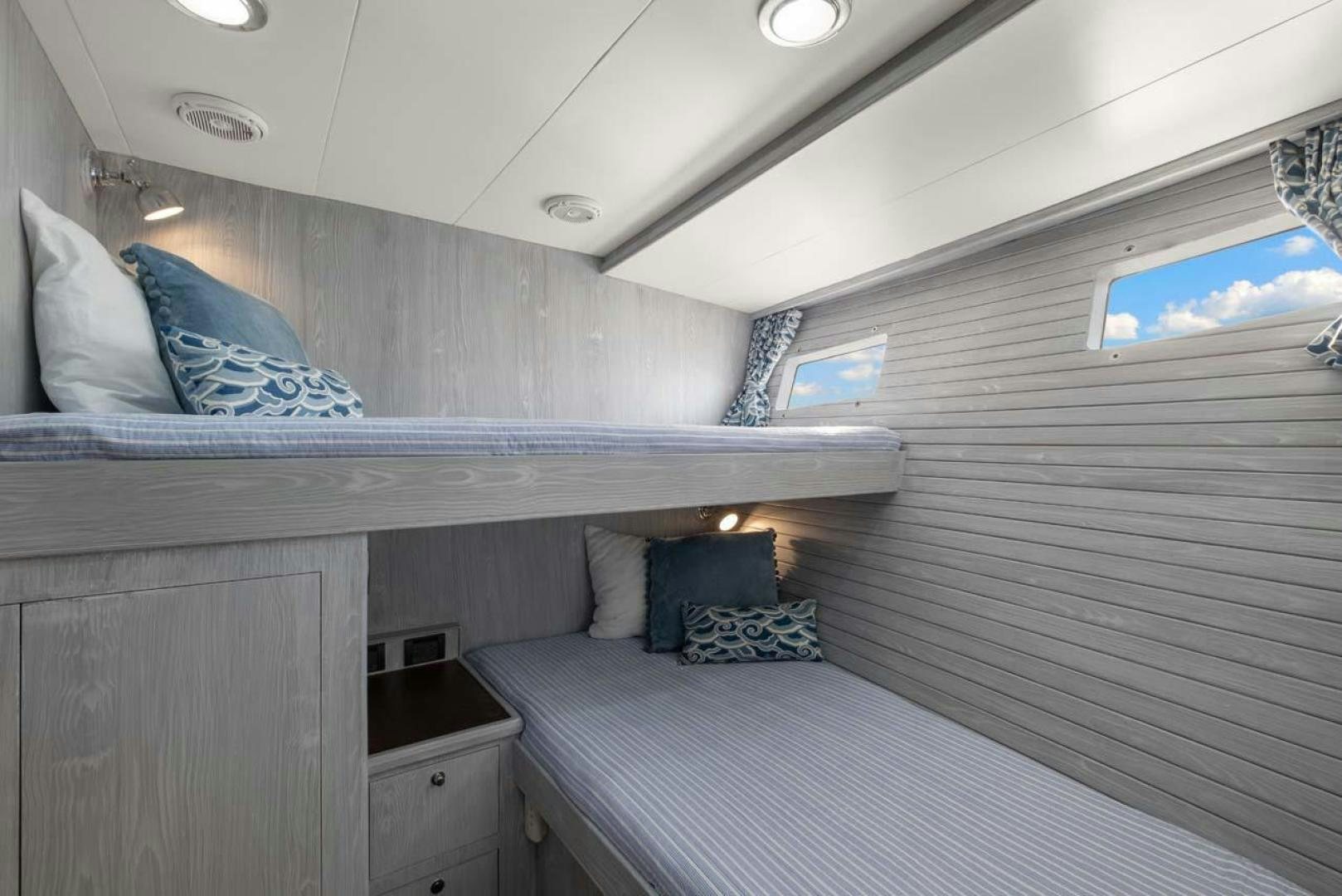 a room with a bed and a window aboard PIVOT Yacht for Sale