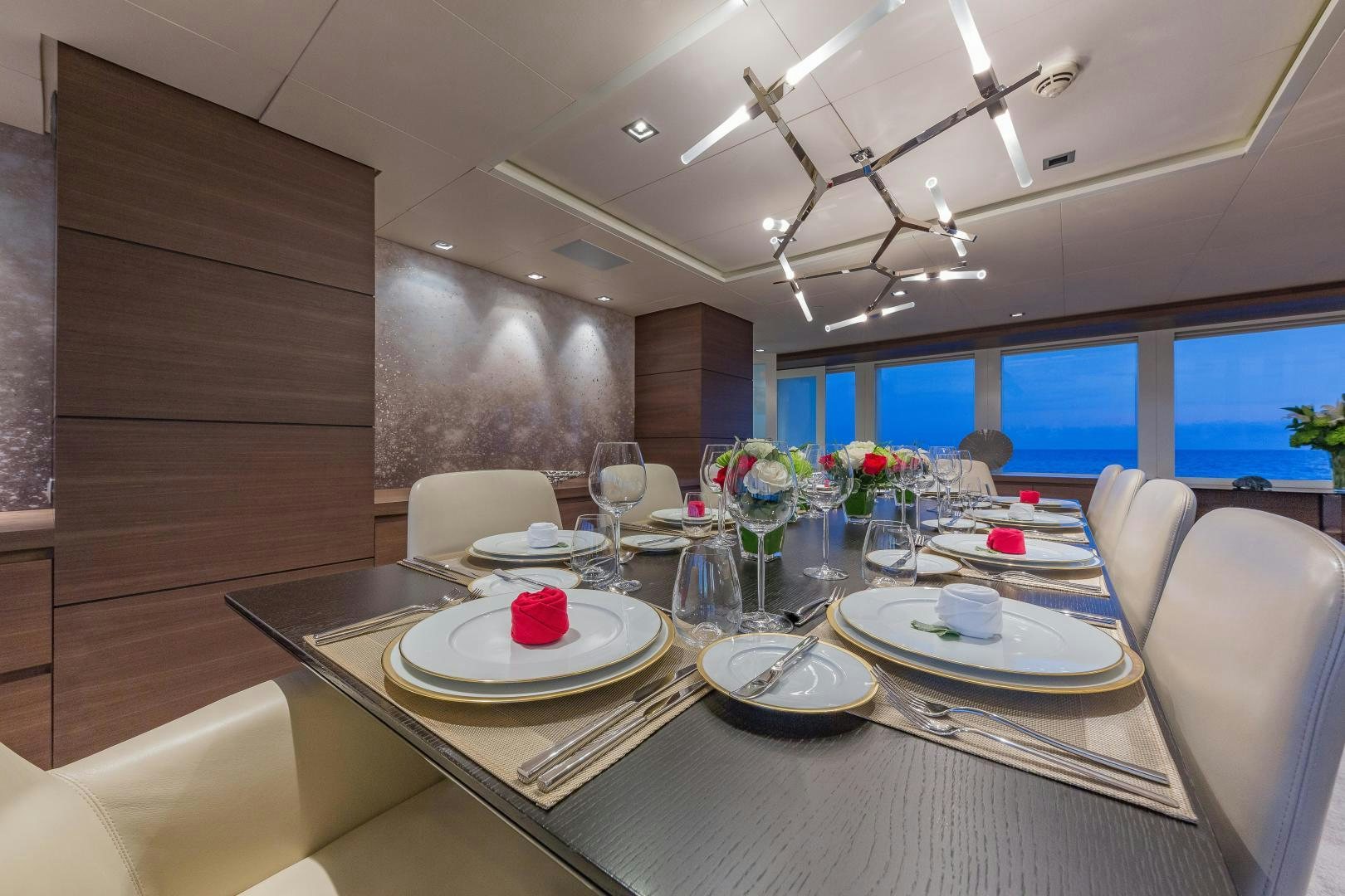 a dining table with plates and glasses aboard BIG SKY Yacht for Sale