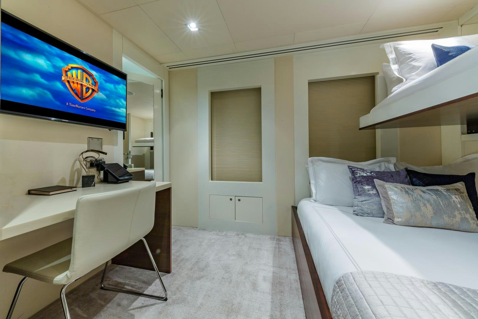 a room with a bed and a tv on the wall aboard BIG SKY Yacht for Sale