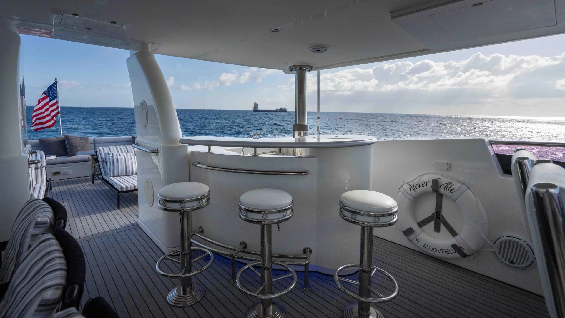 a boat with stools and stools on a deck aboard NEVER SETTLE Yacht for Sale