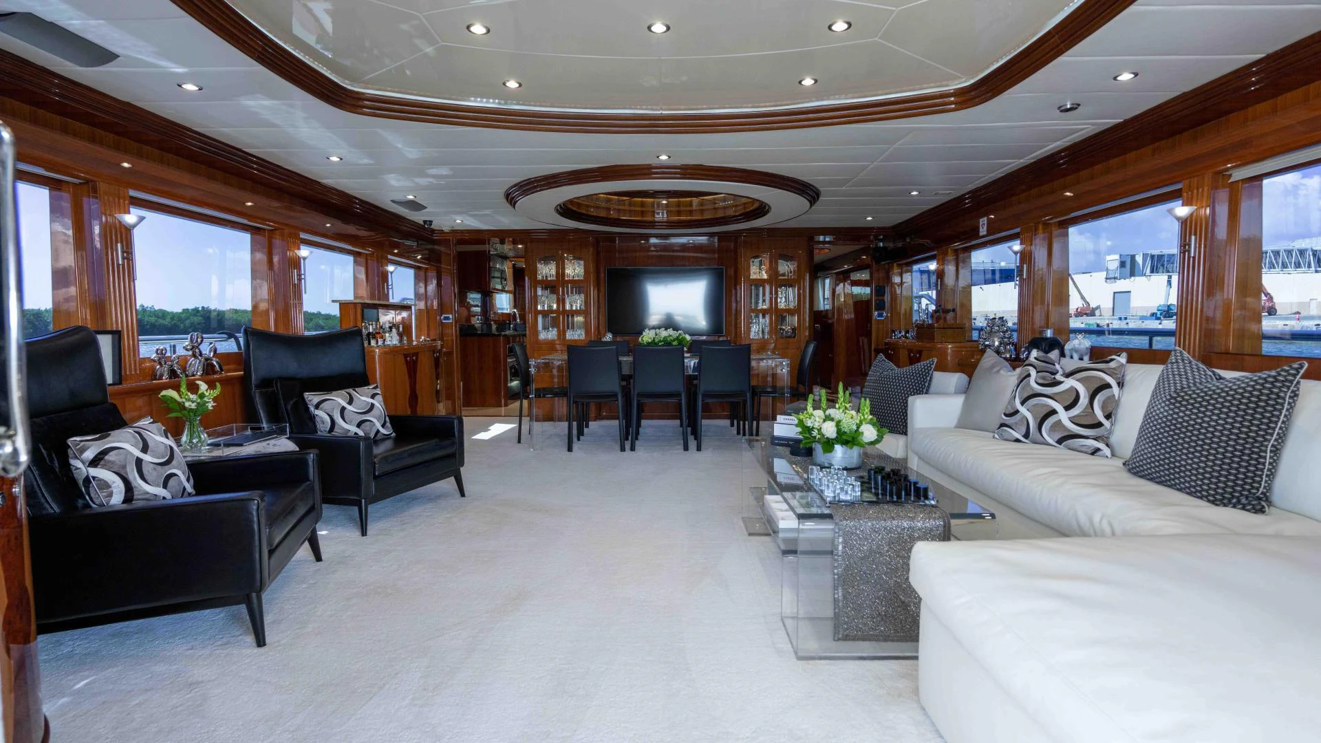 a living room with leather couches and a large chandelier aboard NEVER SETTLE Yacht for Sale