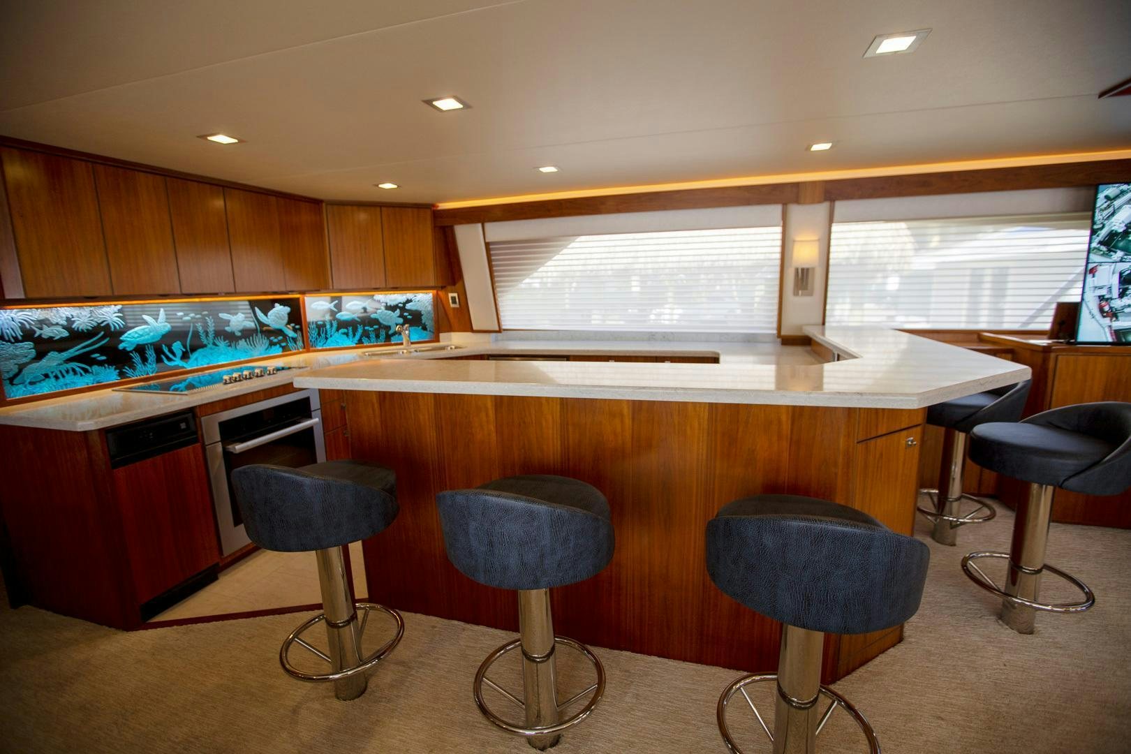 a kitchen with a bar stools and a bar stool aboard REEL HIGH'S Yacht for Sale