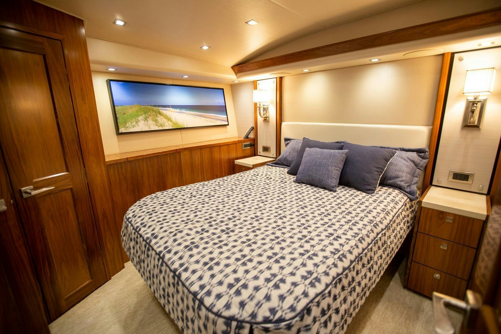 a bed with a blue and white comforter and pillows aboard REEL HIGH'S Yacht for Sale