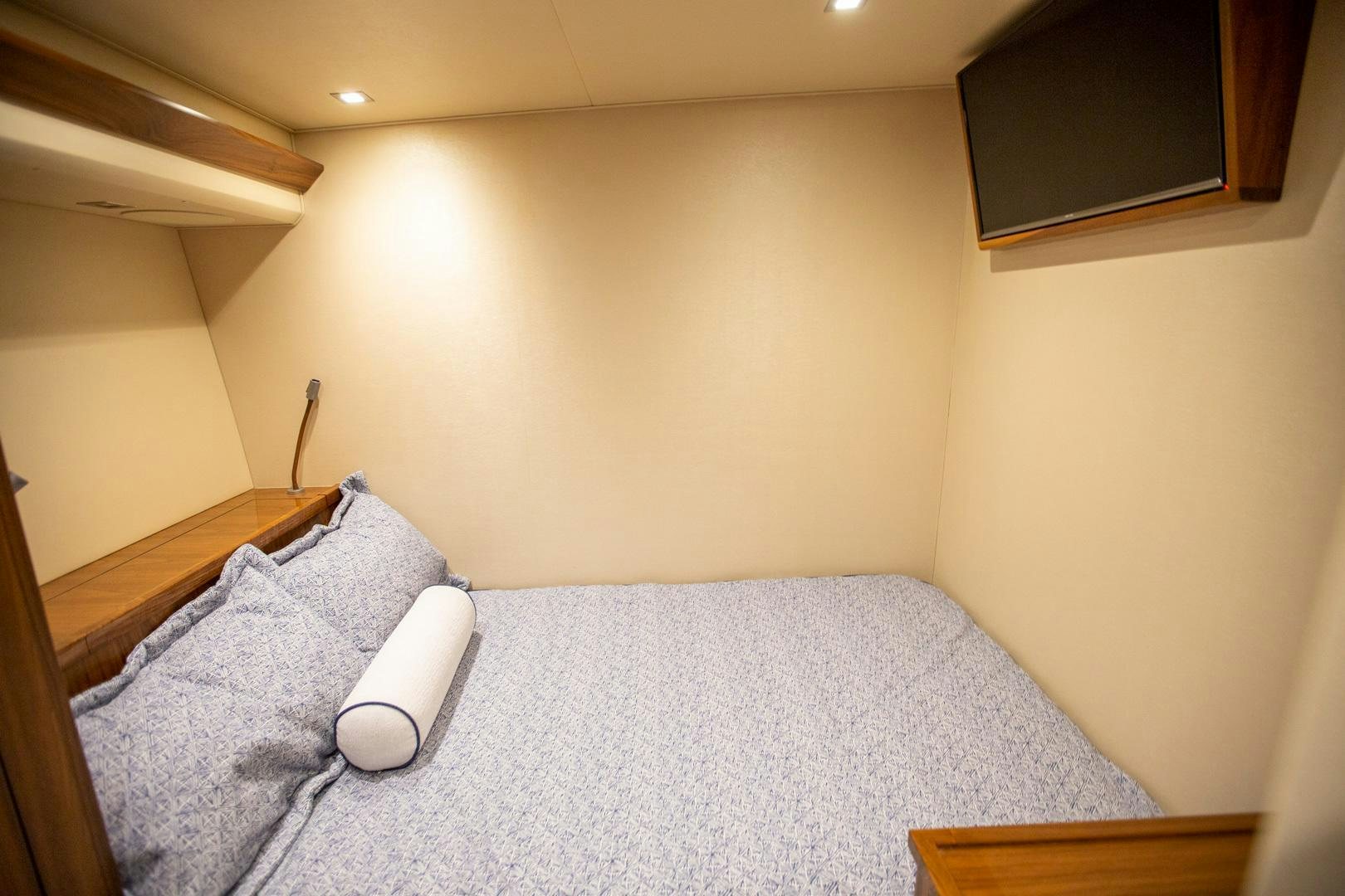 a bed with a lamp on it aboard REEL HIGH'S Yacht for Sale