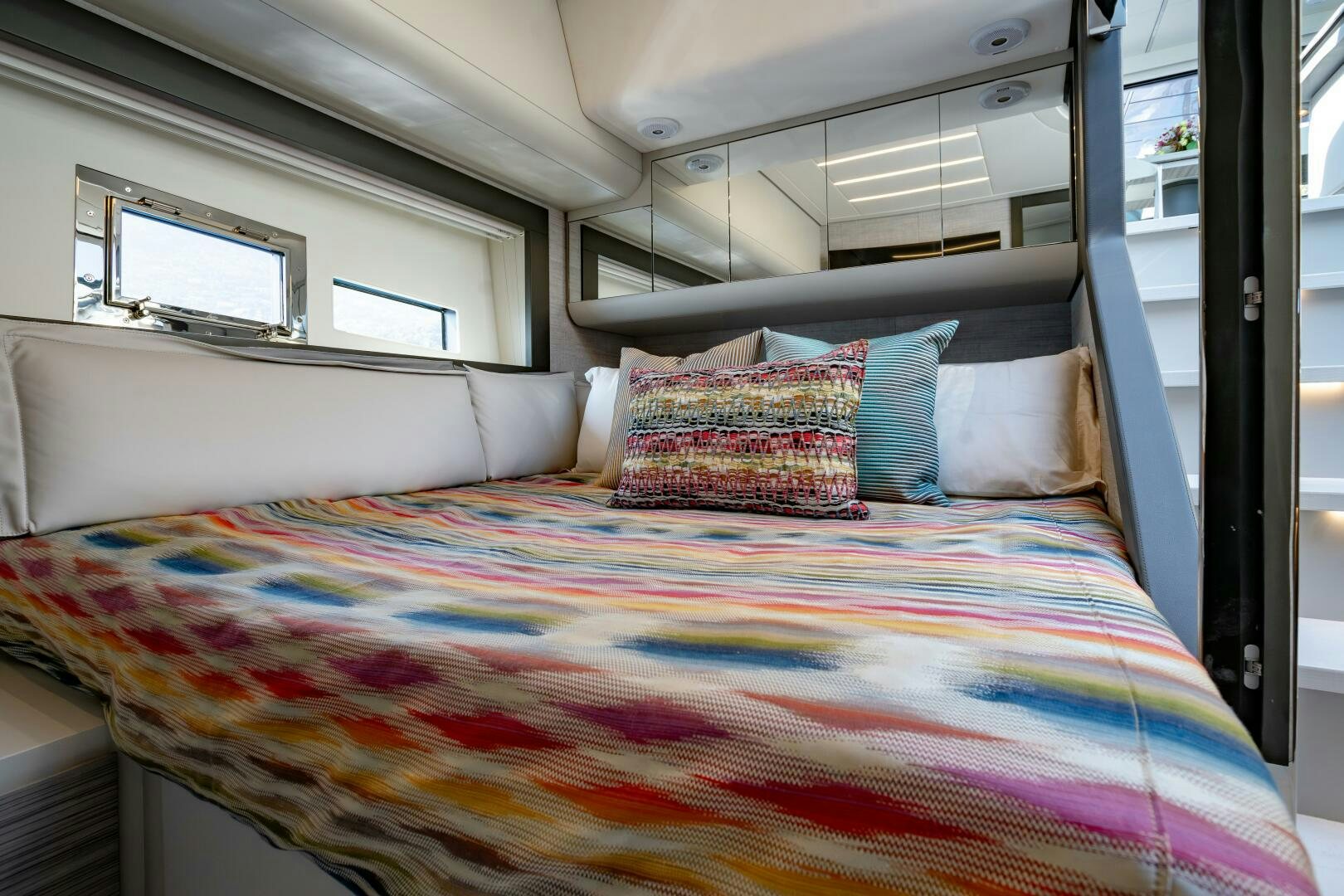 a bed with a colorful comforter aboard SILVER MISSILE Yacht for Sale