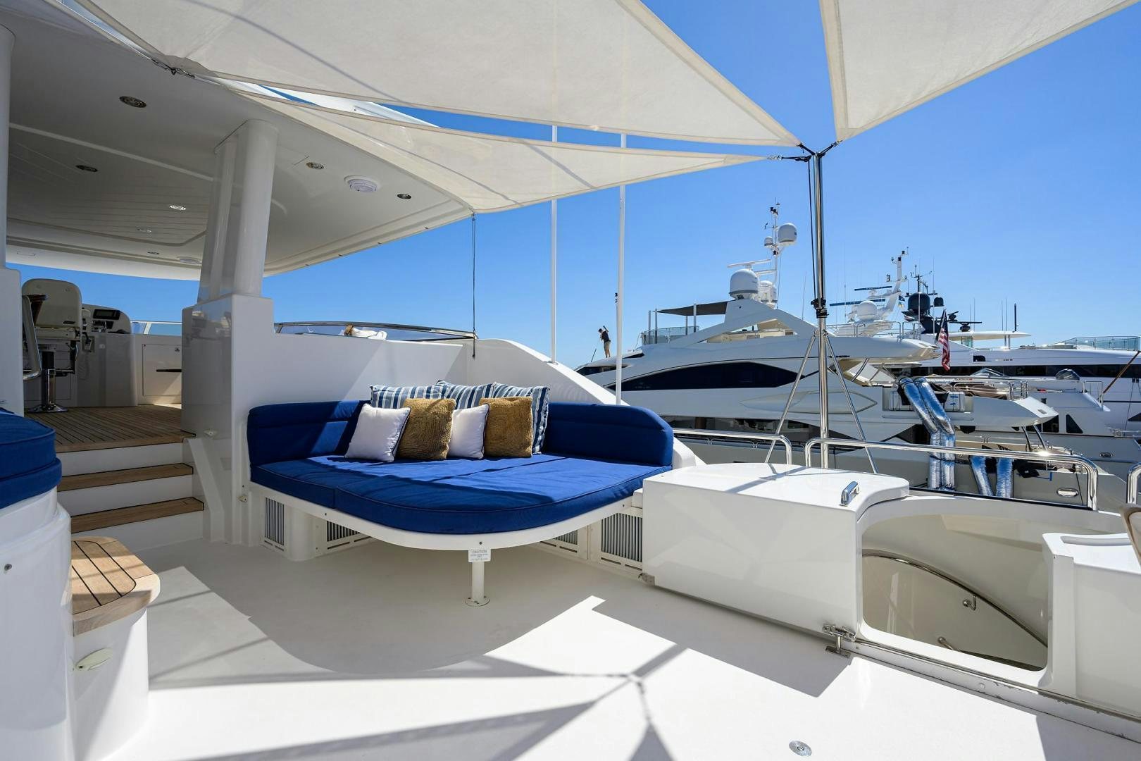 a large room with a bed and a blue couch aboard CERCA TROVA Yacht for Sale