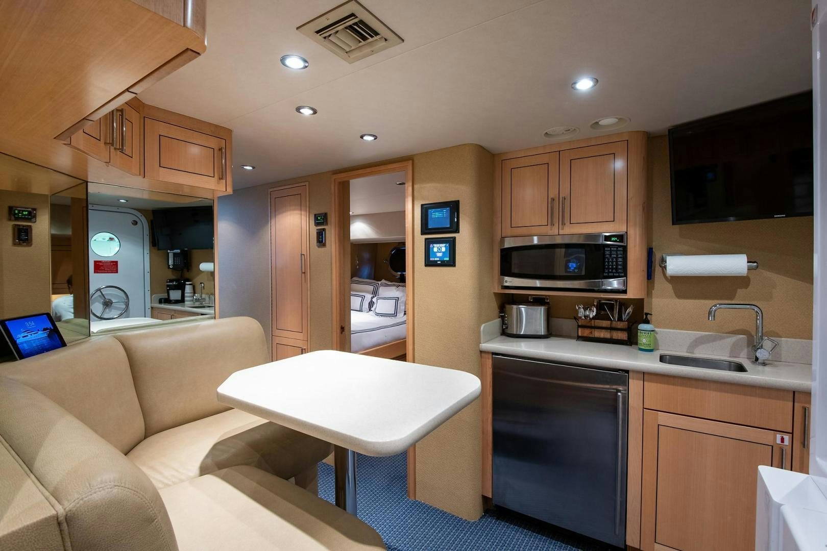 a living room with a couch and a kitchen aboard CERCA TROVA Yacht for Sale