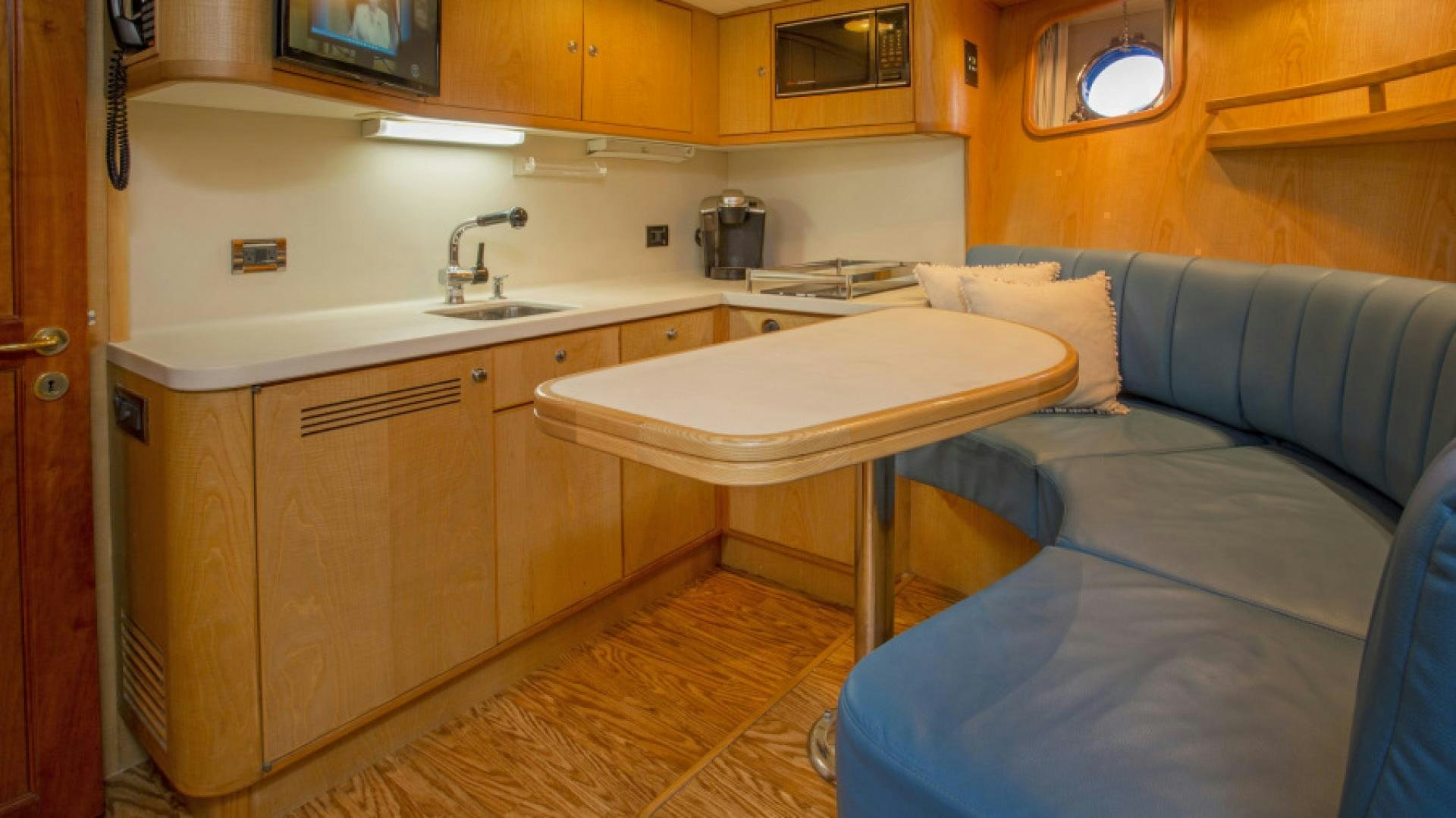 a kitchen with a table and a couch aboard MYU Yacht for Sale
