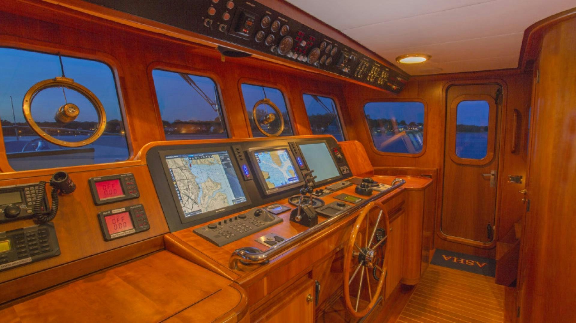 a yellow school bus with a large desk and computer screens aboard MYU Yacht for Sale