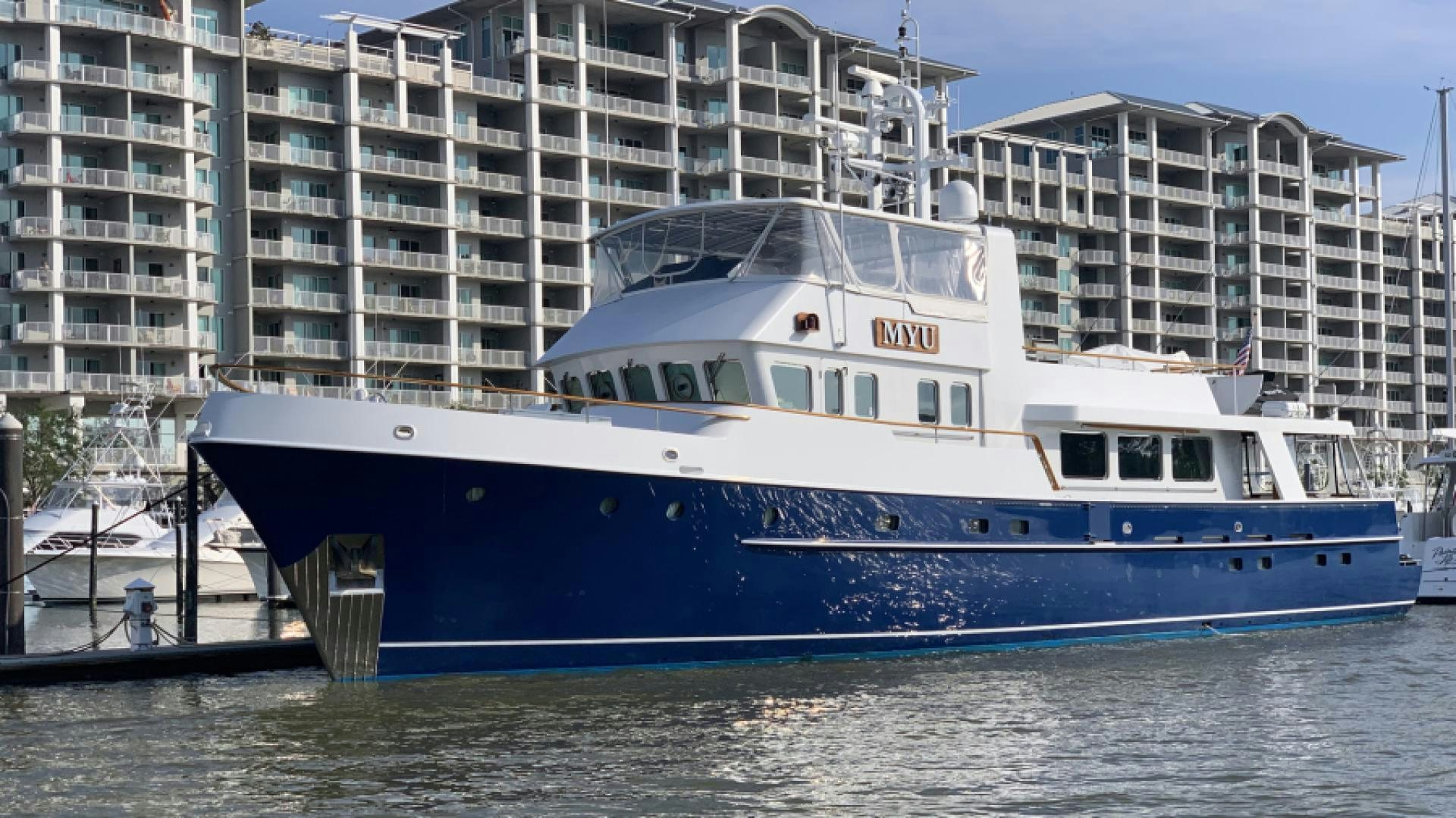 a large white boat in a harbor aboard MYU Yacht for Sale