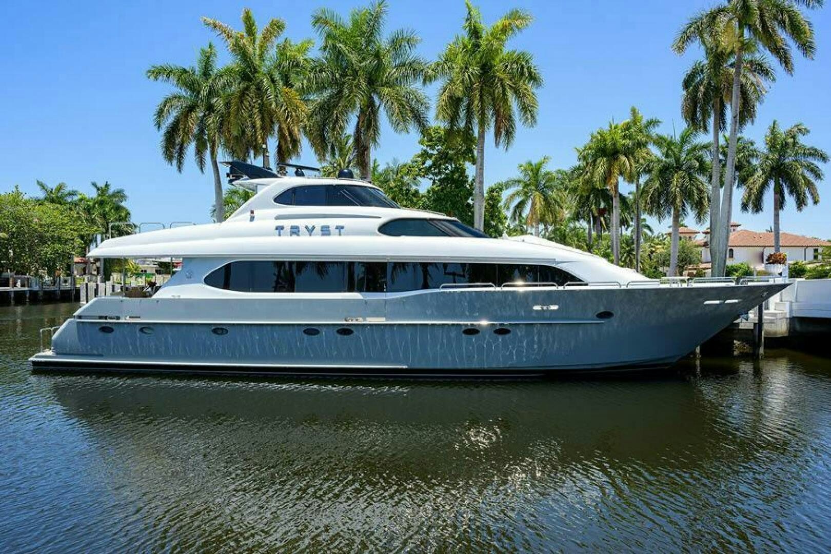 a white yacht in a harbor aboard TRYST Yacht for Sale