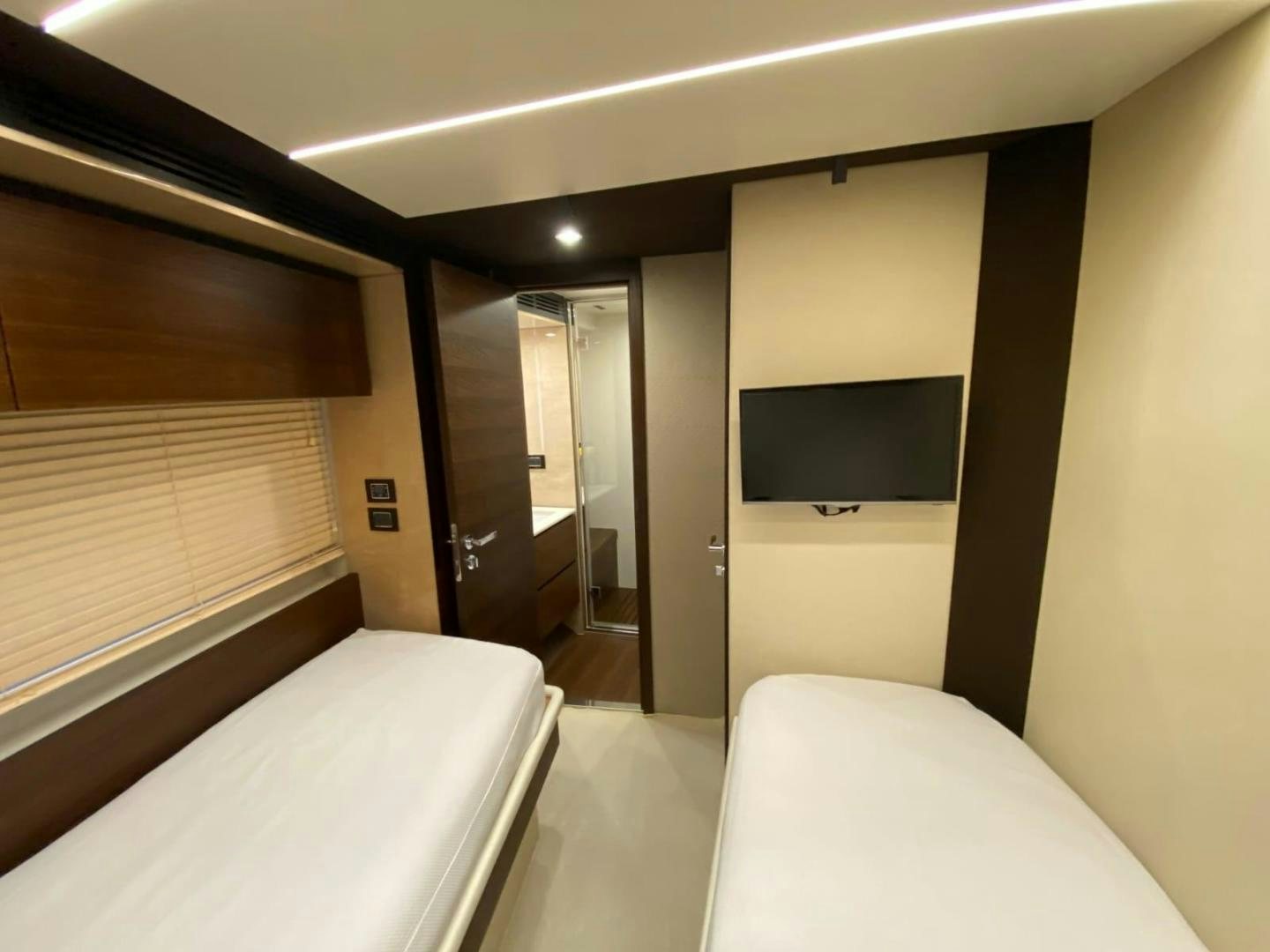 a room with a bed and a television aboard PASEO Yacht for Sale