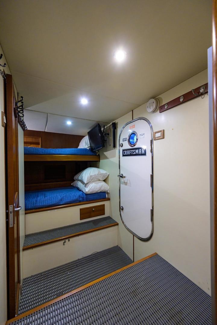 a bunk bed with a blue and white striped bed spread aboard HARD TIMES NAME RESERVED Yacht for Sale
