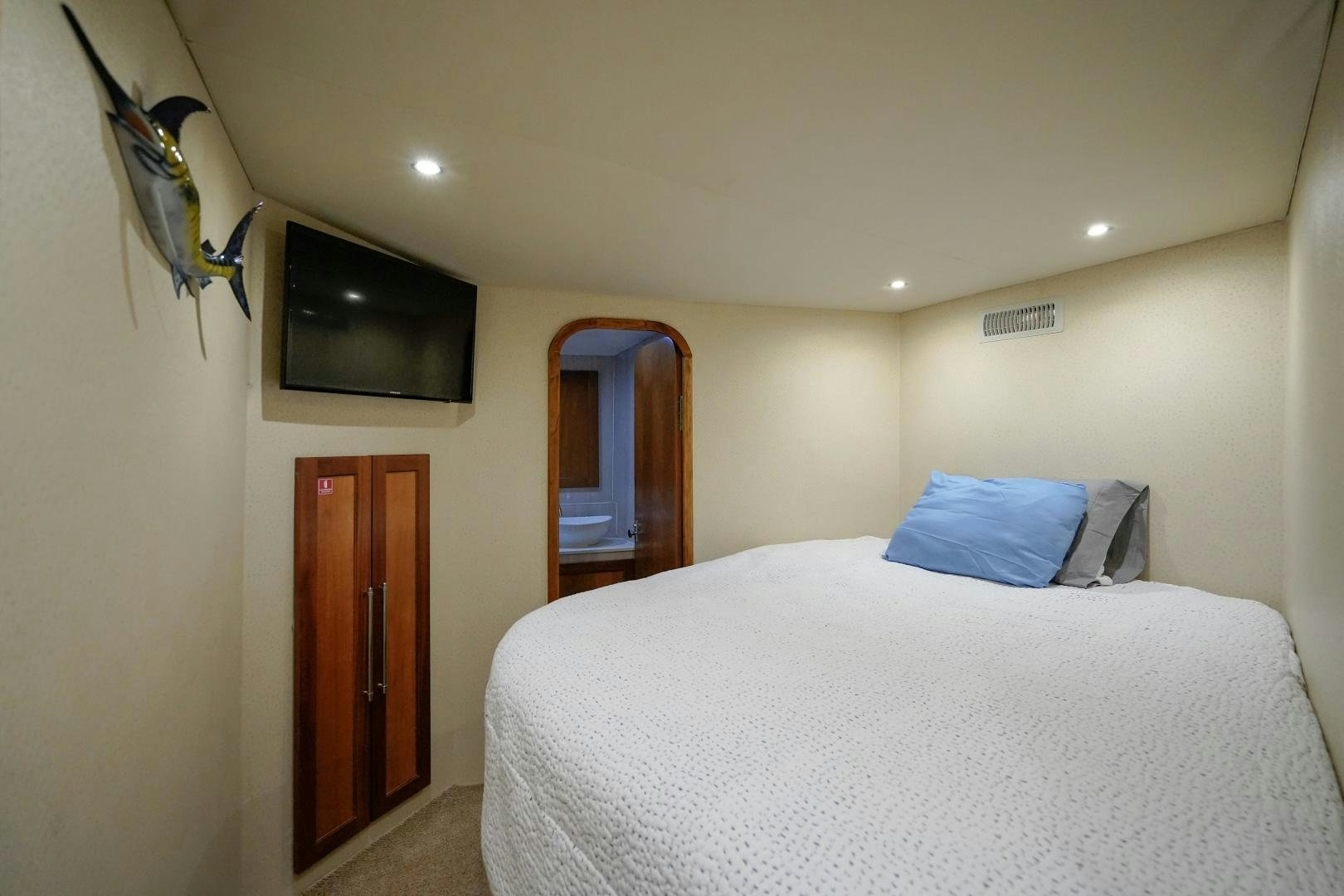 a bedroom with a bed and a television aboard BIG ENOS Yacht for Sale
