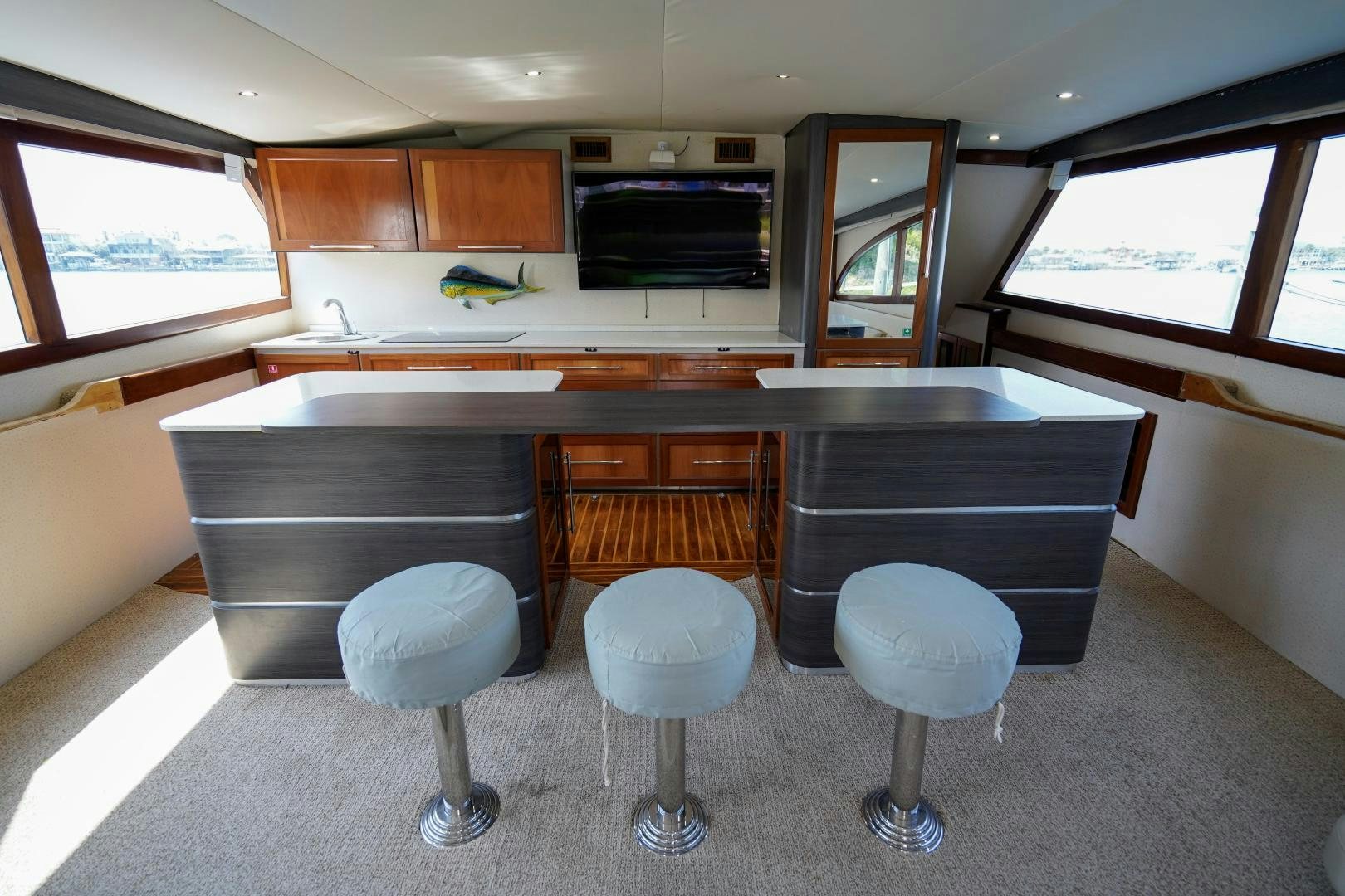 a kitchen with stools and a bar aboard BIG ENOS Yacht for Sale