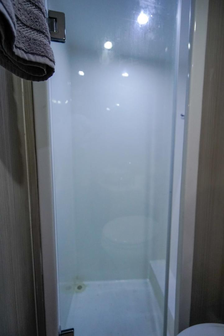 a shower with a towel on the wall aboard BIG ENOS Yacht for Sale