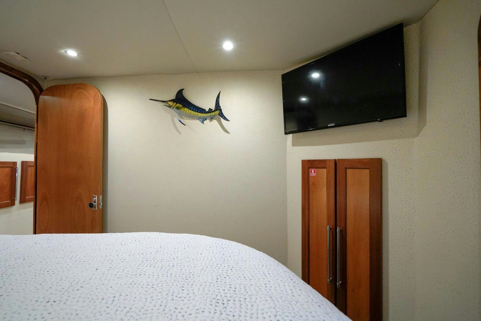 a bedroom with a television and a bed aboard BIG ENOS Yacht for Sale