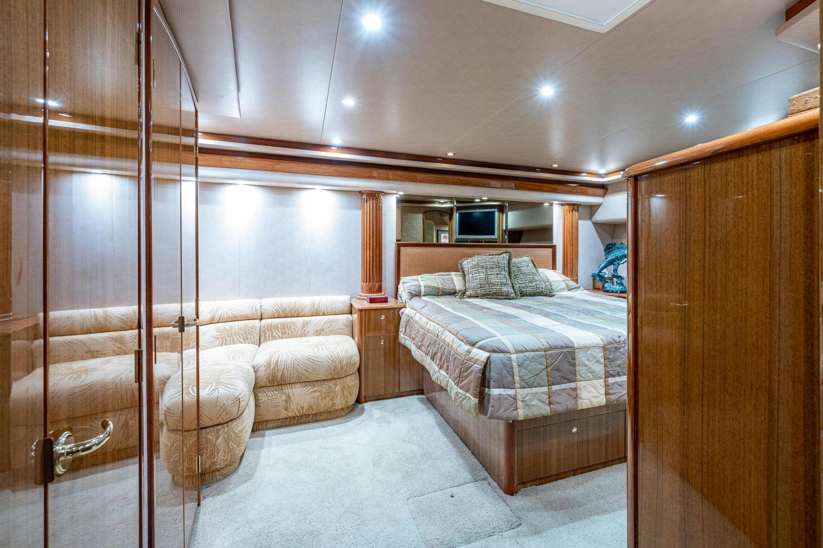 a bedroom with a bed and a wood cabinet aboard REEL ESTATE Yacht for Sale