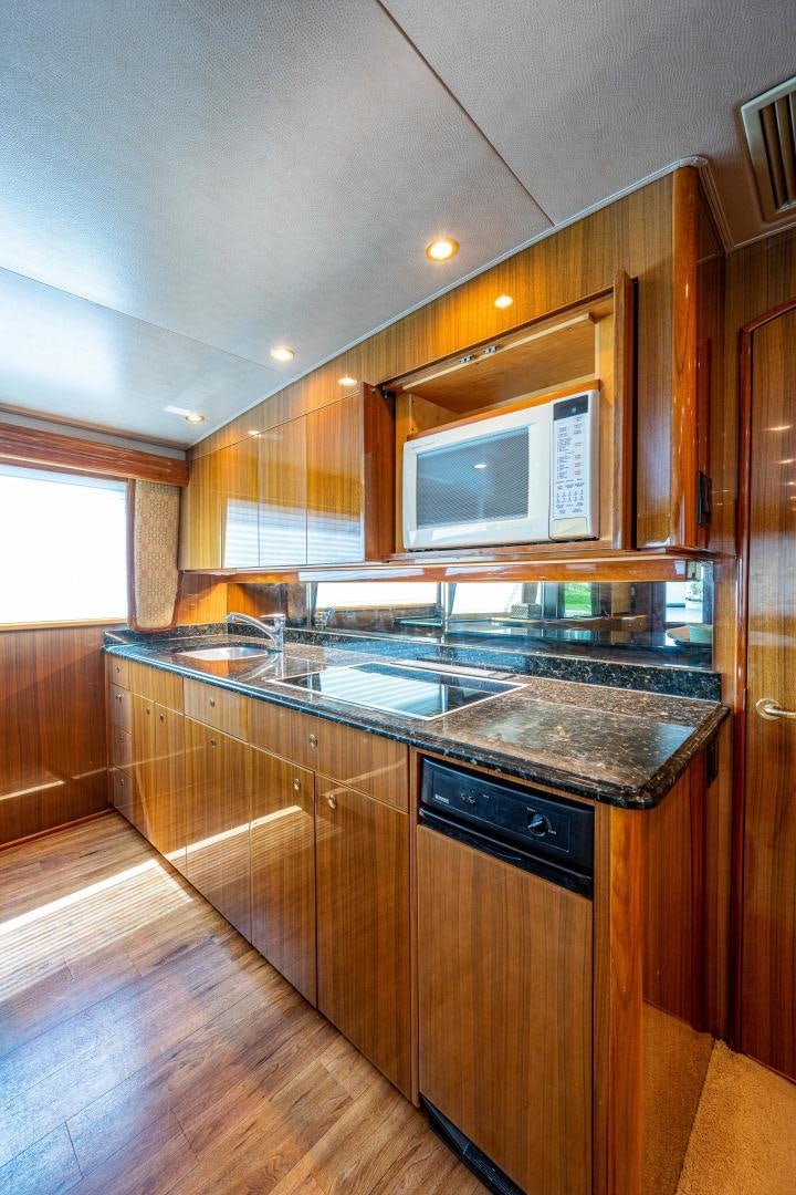 a kitchen with wooden cabinets aboard REEL ESTATE Yacht for Sale