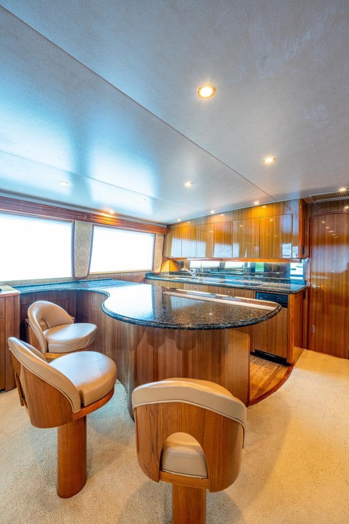 a room with a bar and chairs aboard REEL ESTATE Yacht for Sale