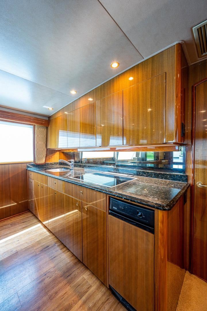 a kitchen with wooden cabinets aboard REEL ESTATE Yacht for Sale