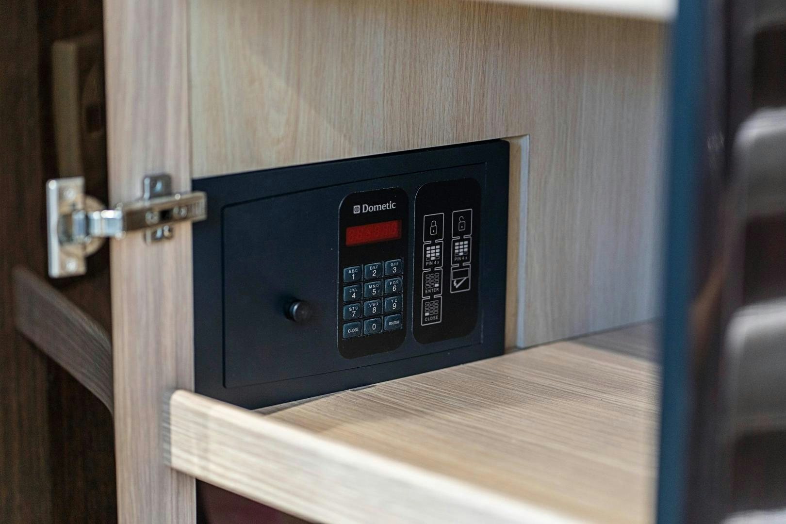 a black rectangular object with a red button on a wooden surface aboard QUANTUM Yacht for Sale