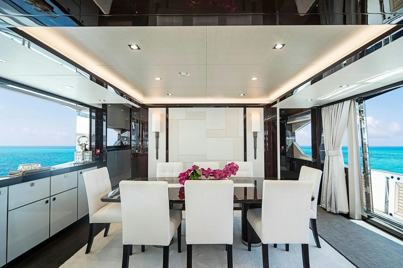 a large kitchen with white cabinets and white chairs aboard QUANTUM Yacht for Sale